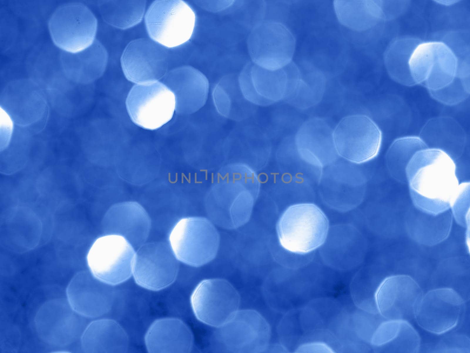 Sparkling background with bokeh made of blue color. Blurred backdrop for holidays and parties. Copy space for text