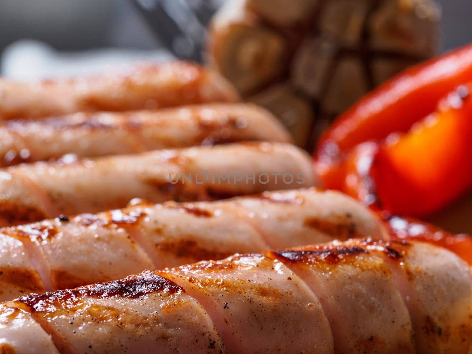 Close up view of chicken homemade sausages. Grilled sausages and grilled vegetables. Copy space.