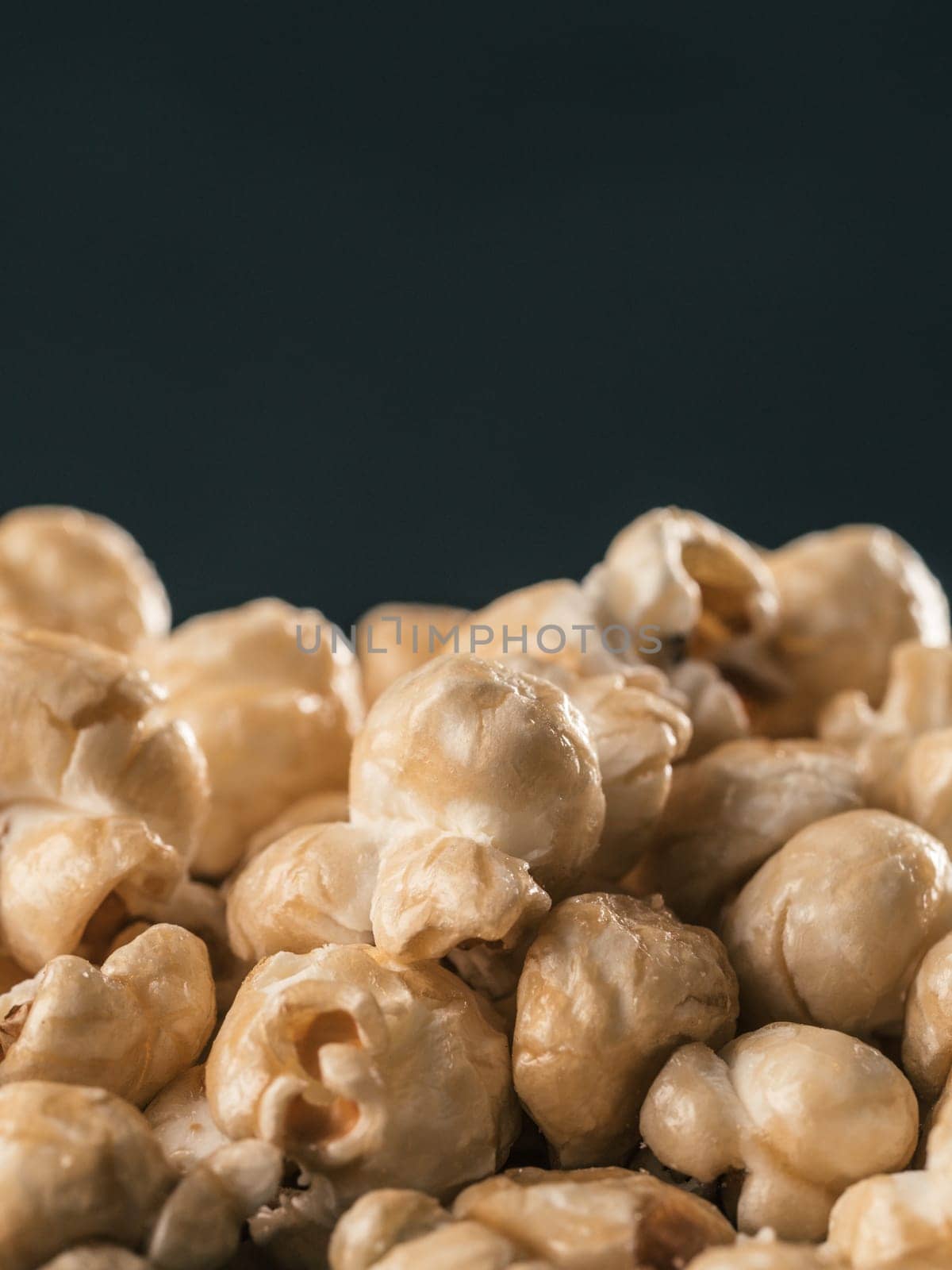 pile of caramel corn on black background by fascinadora