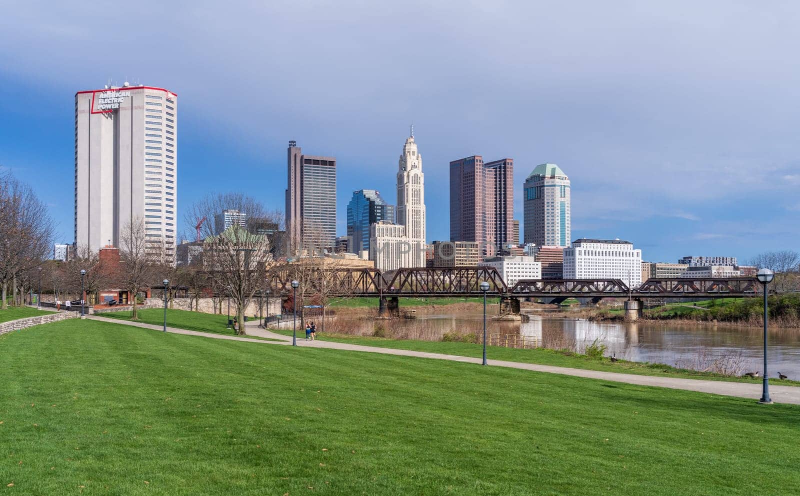 Columbus, OH - 7 April 2024: Waterfront view of the downtown financial district from the River Scioto through a railroad truss bridge