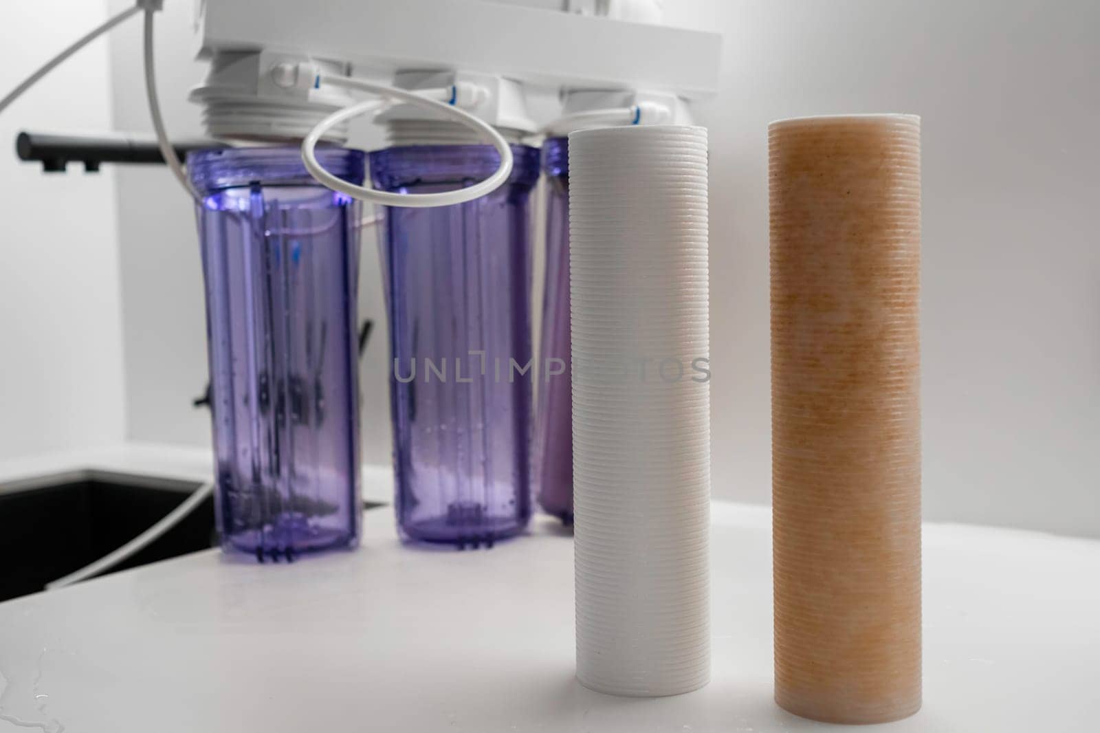Dirty and clean filters for reverse osmosis on the table in the modern kitchen by vladimka