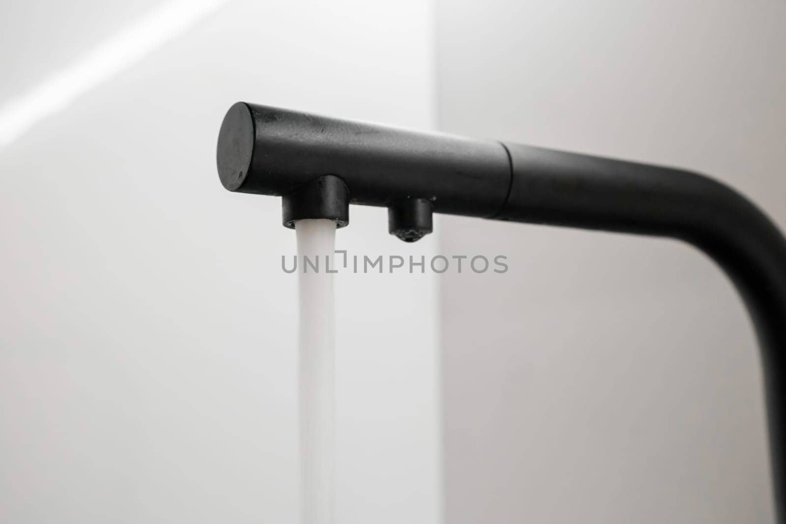 Modern black kitchen faucet with flowing tap water by vladimka