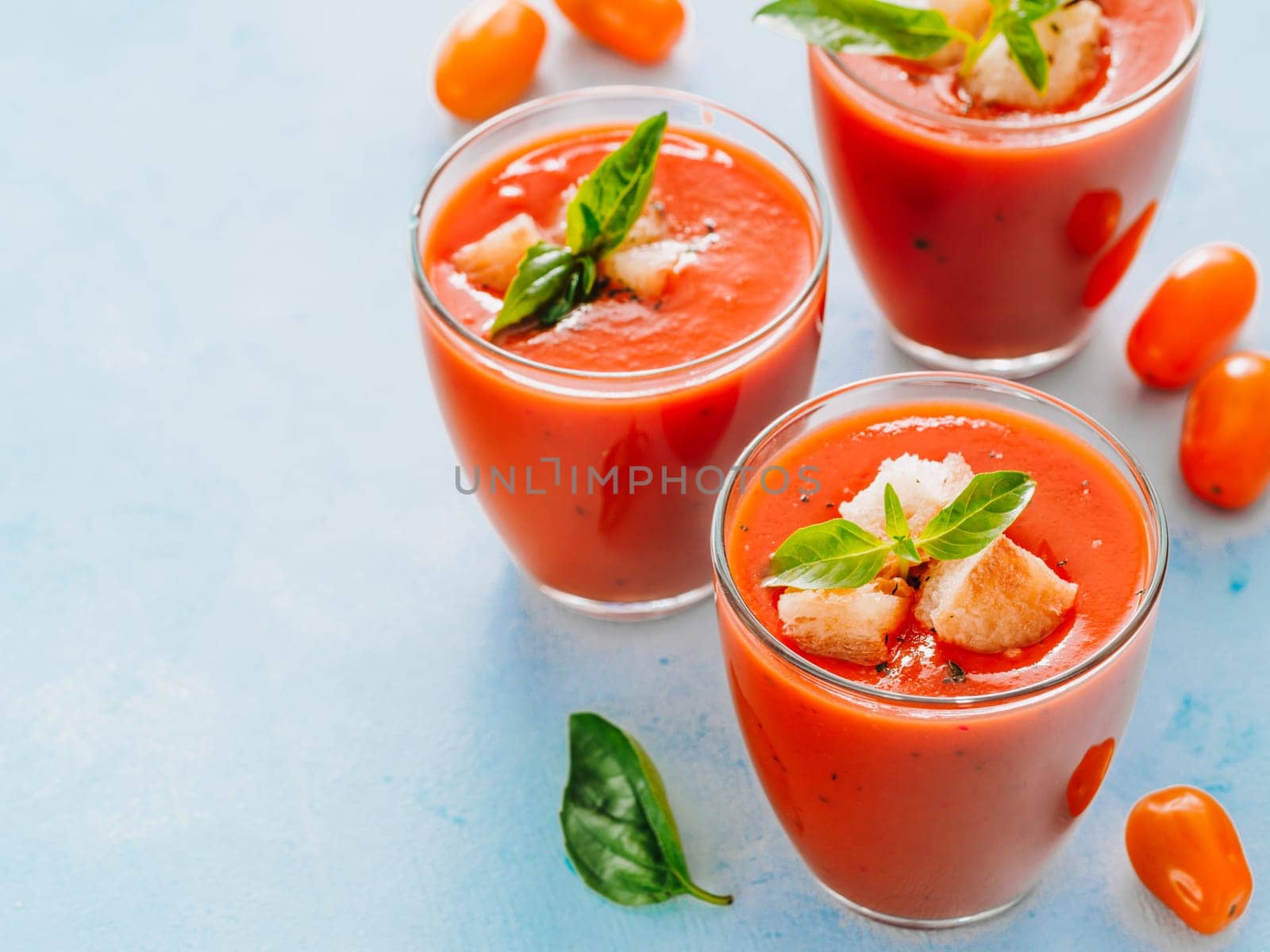 Delicious gaspacho soup in glass. Traditional spanish cold soup puree gaspacho or gazpacho on gray cement background with copy space for text. View from above or top view or flat lay