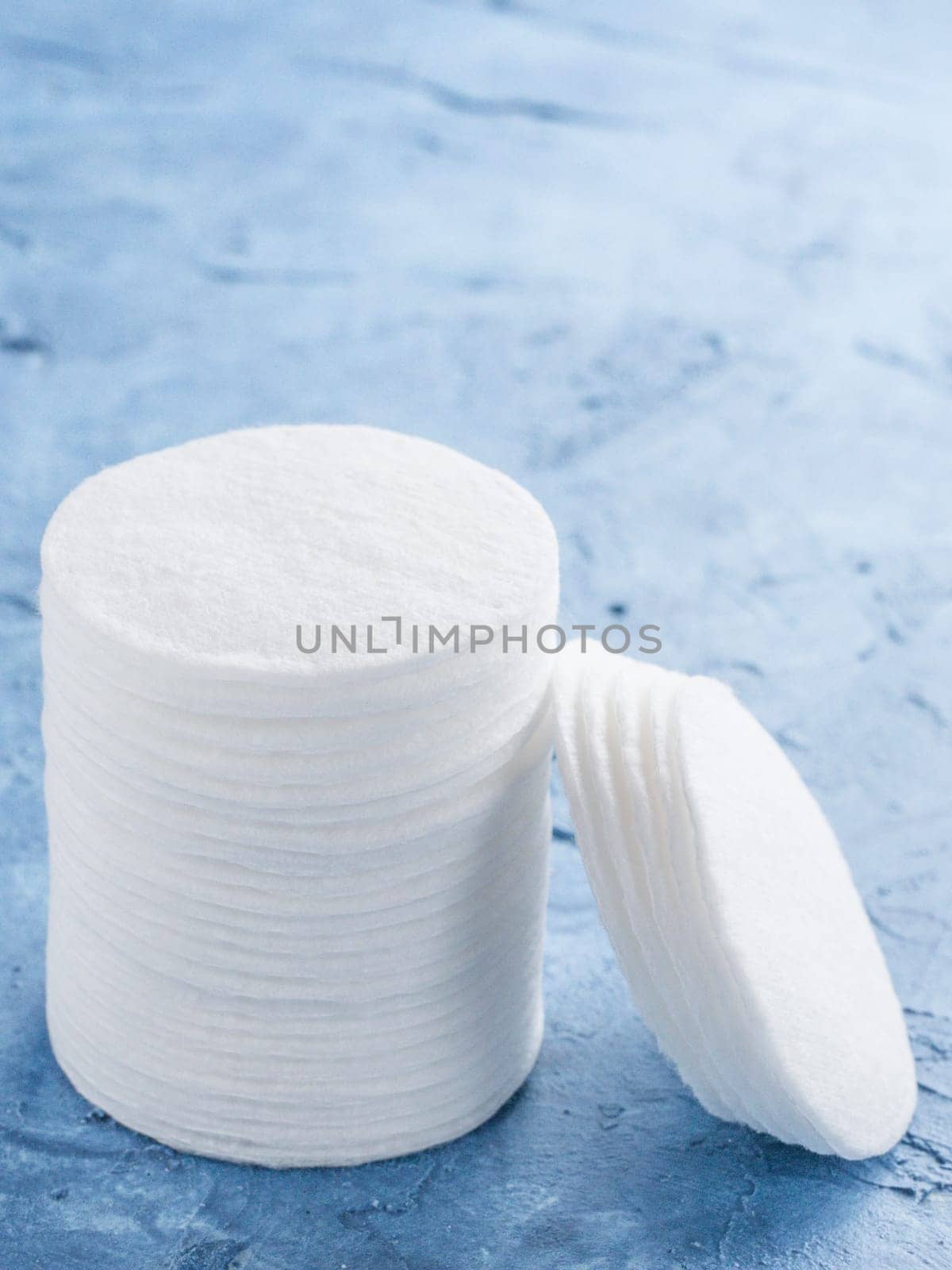 cotton pads on blue concrete background close up