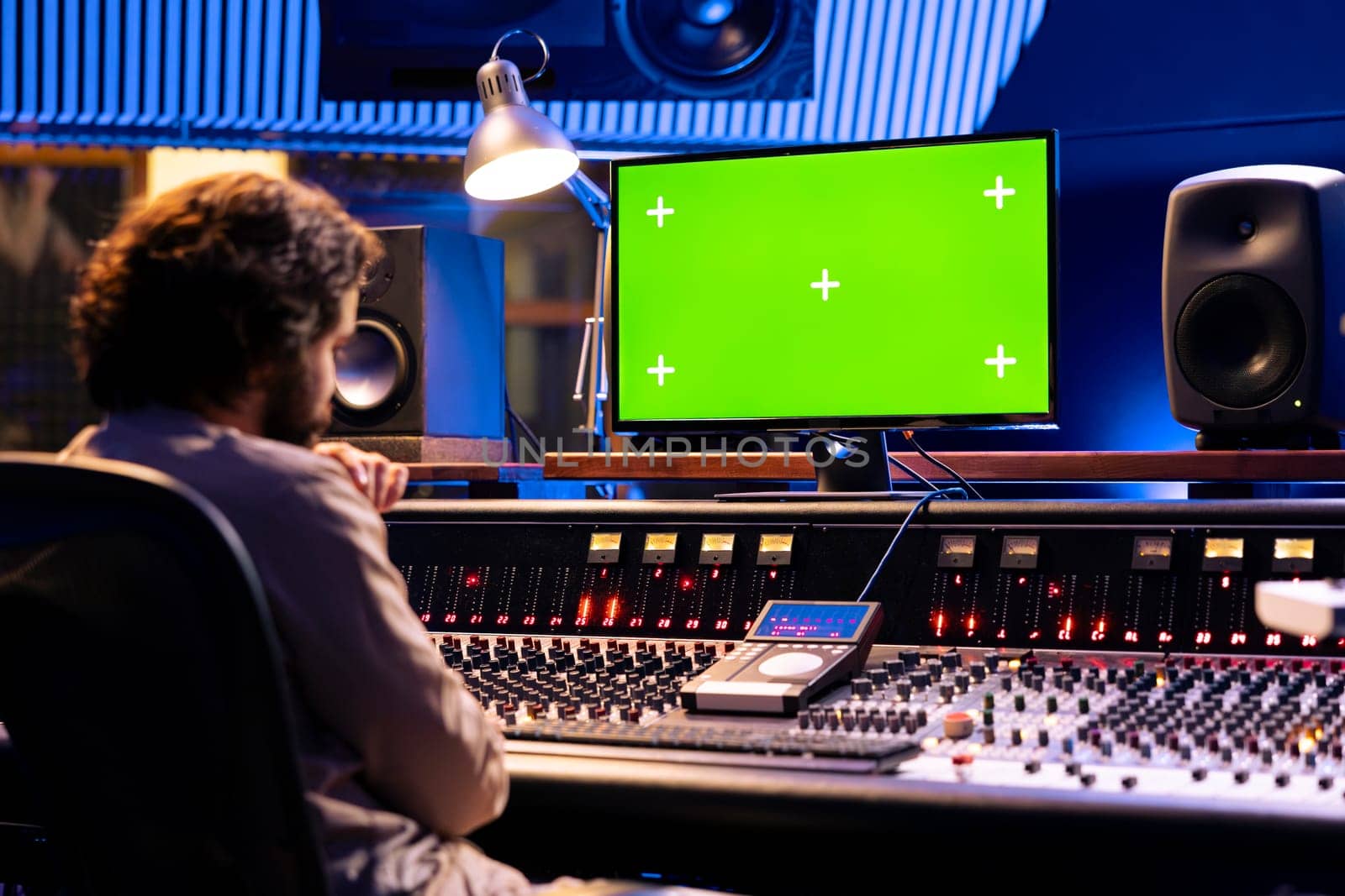Sound engineer working with isolated display in studio control room by DCStudio