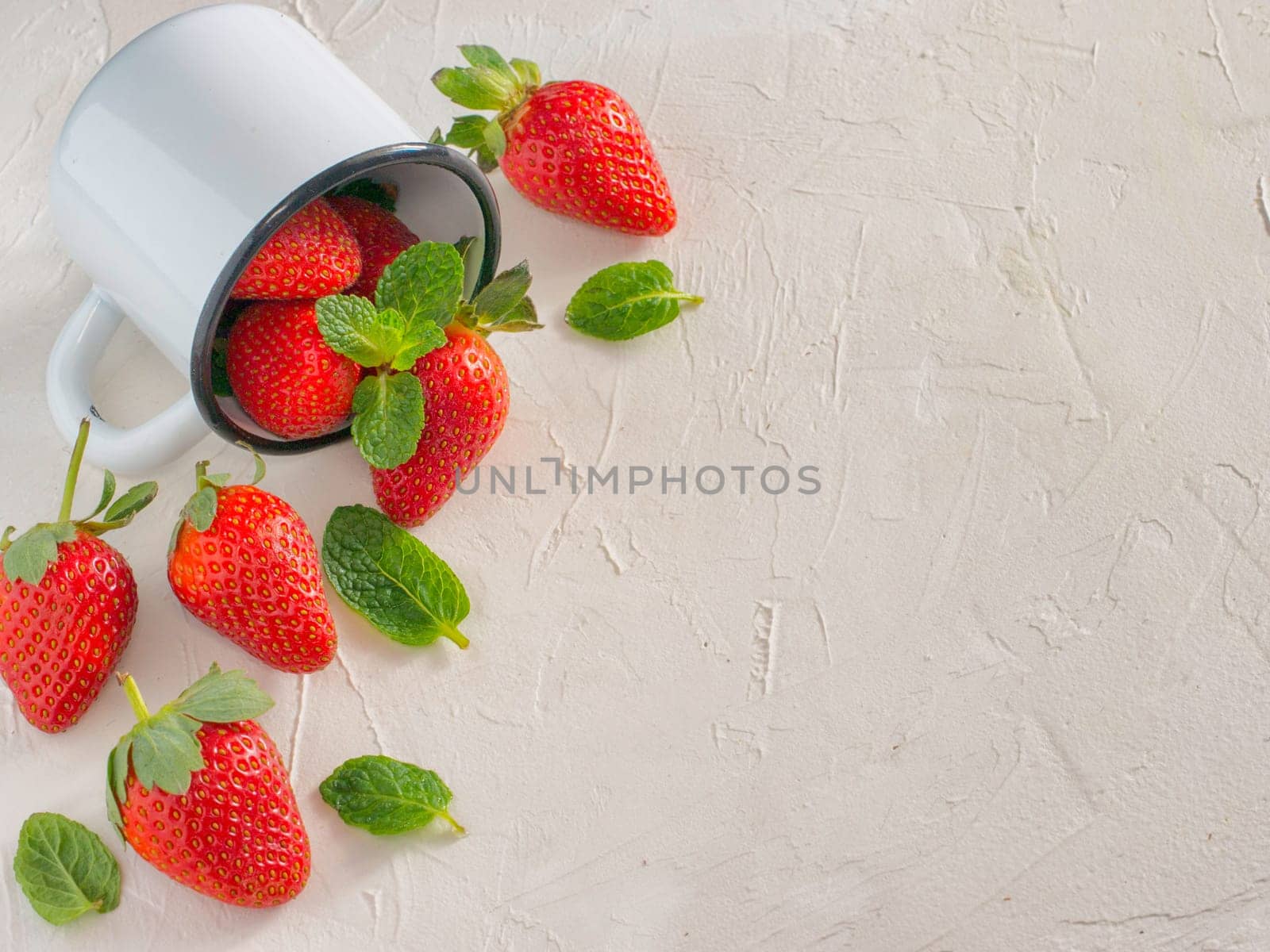 Fresh red strawberries in metal cup. Strawberry in rustic cup on oriental white background. Top view or flat lay