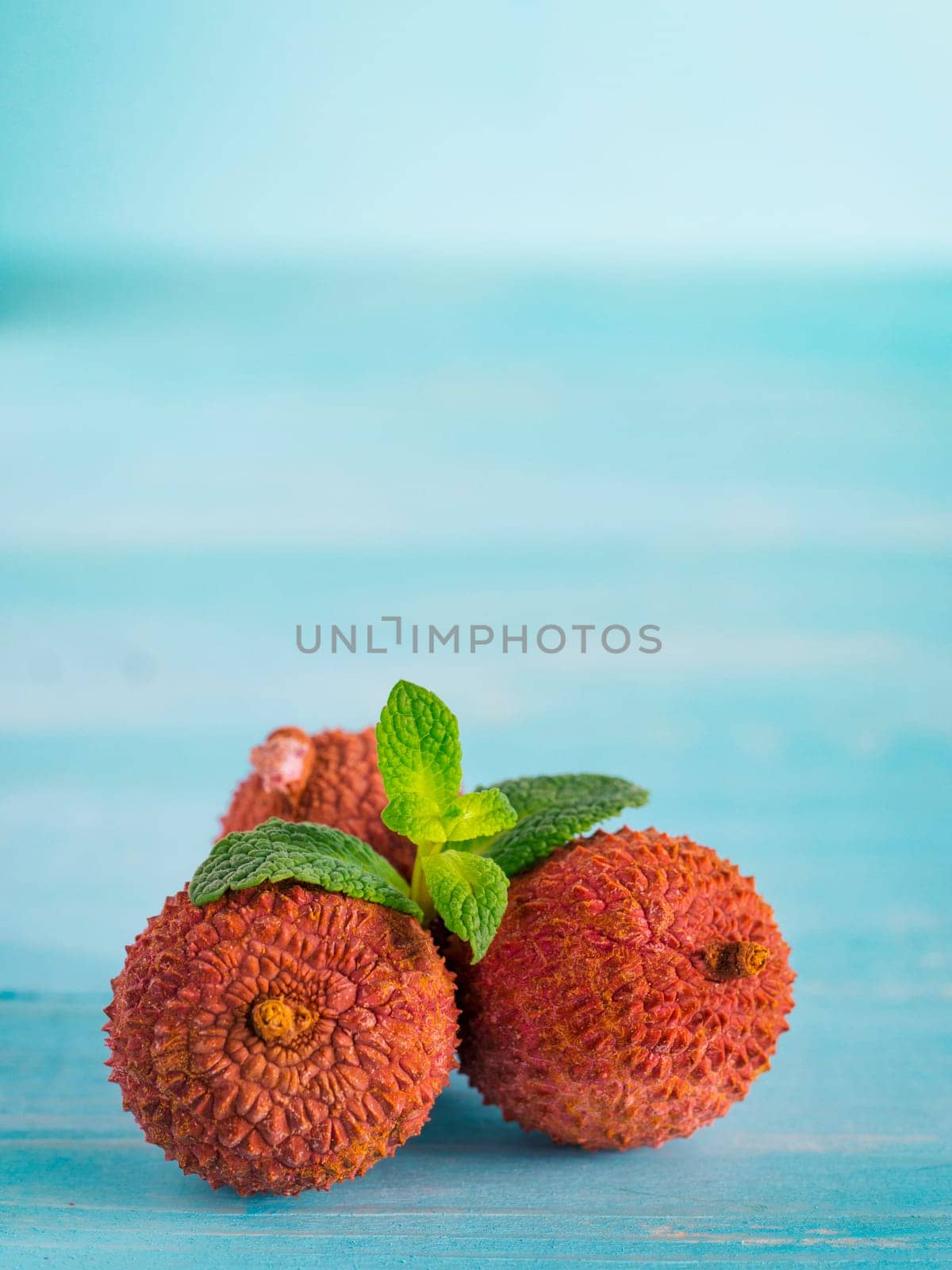 lichee fruit on turquoise wooden background close up