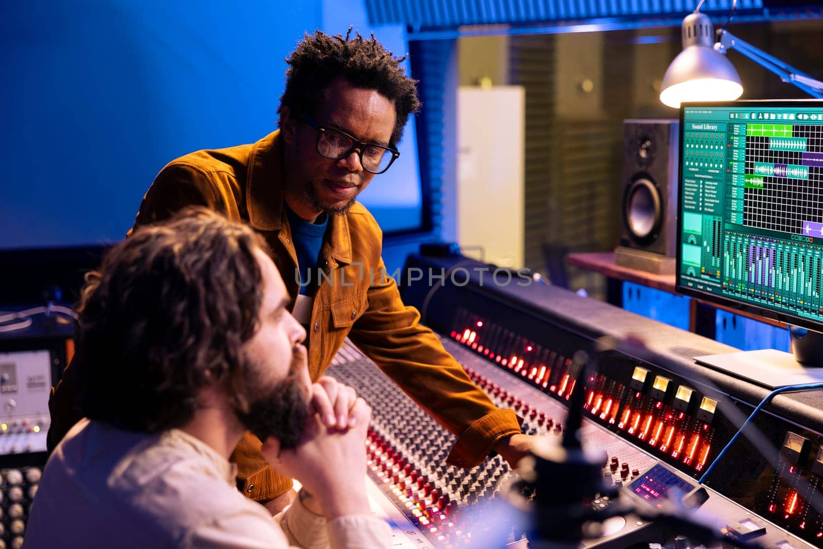 African american artist works with producer in professional studio by DCStudio