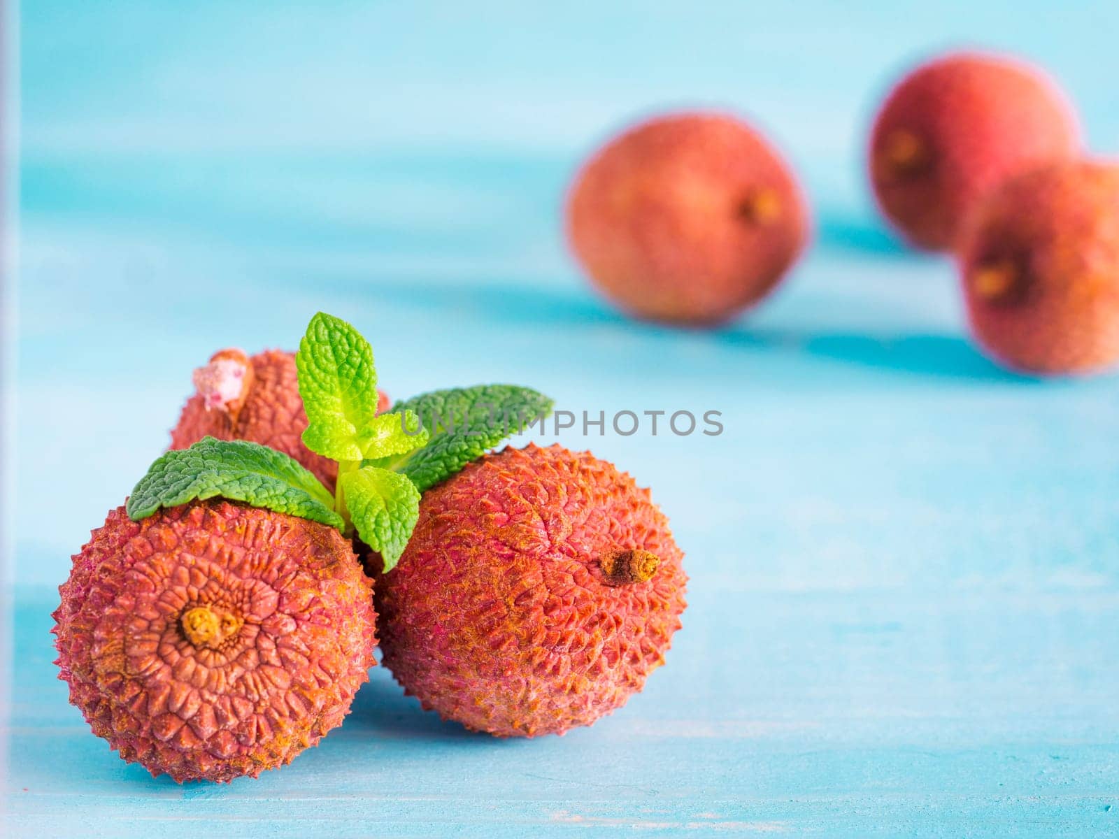 lichee fruit on turquoise wooden background close up