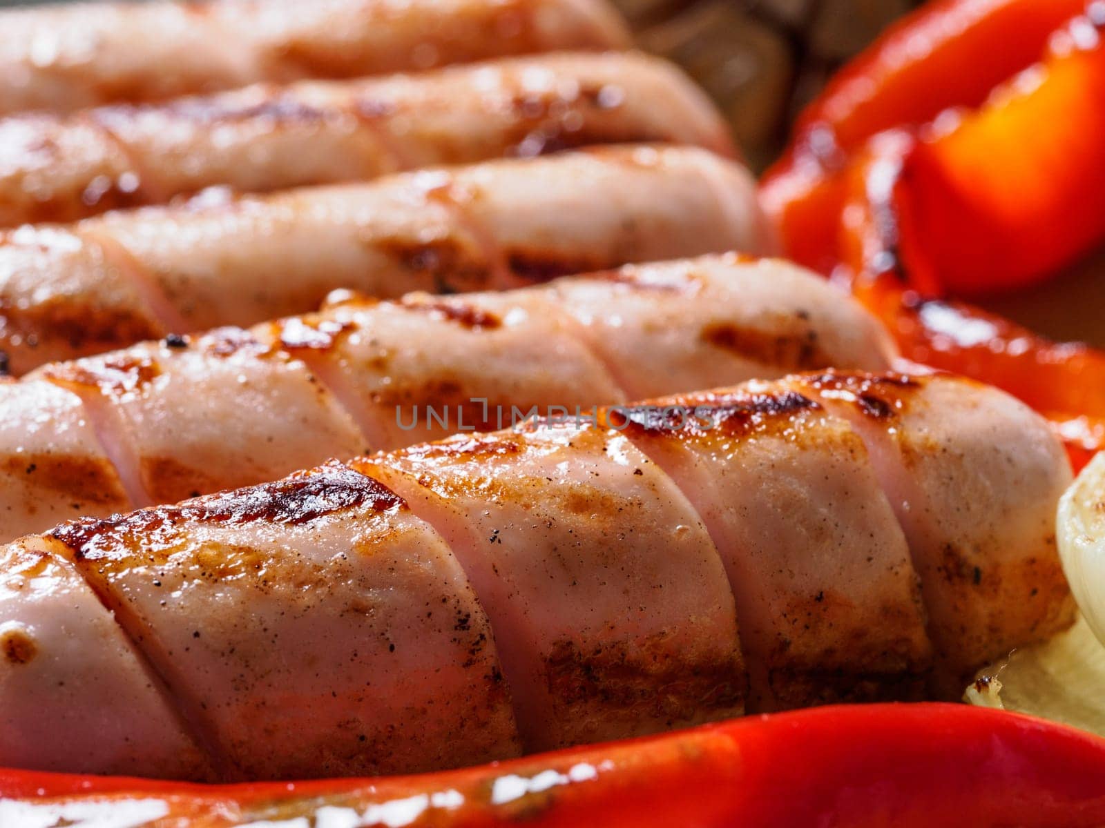 Close up view of chicken homemade sausages. Grilled sausages and grilled vegetables. Copy space.