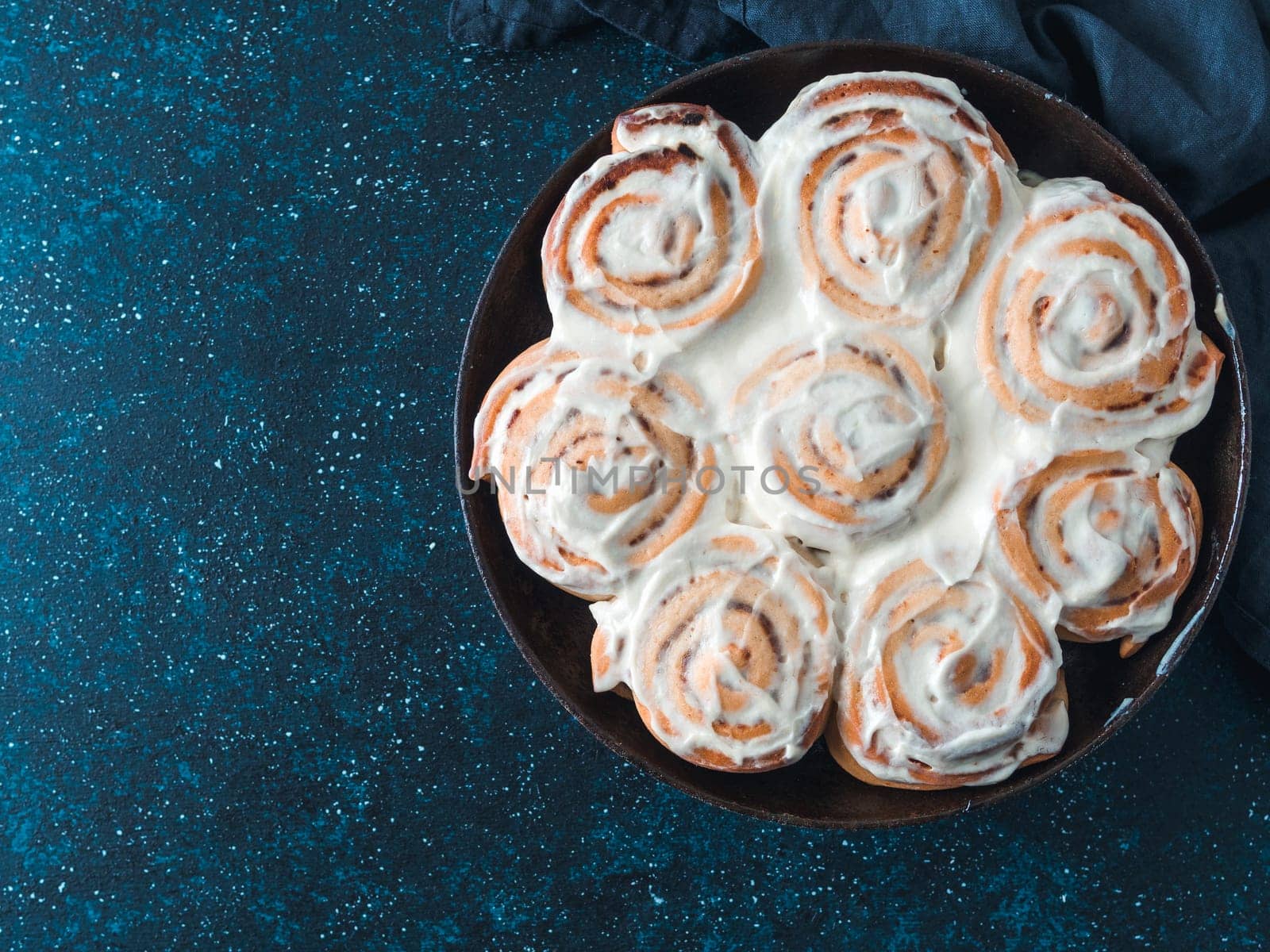 Idea and recipe pastries - perfect cinnamon rolls with topping, top view in skillet. Vegan swedish cinnamon buns Kanelbullar with pumpkin spice,topping vegan cream cheese.Flat lay. Copy space for text