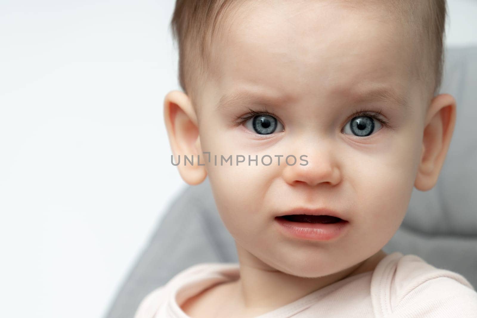 Portrait of sad and upset toddler baby because of being hungry and tired by Mariakray
