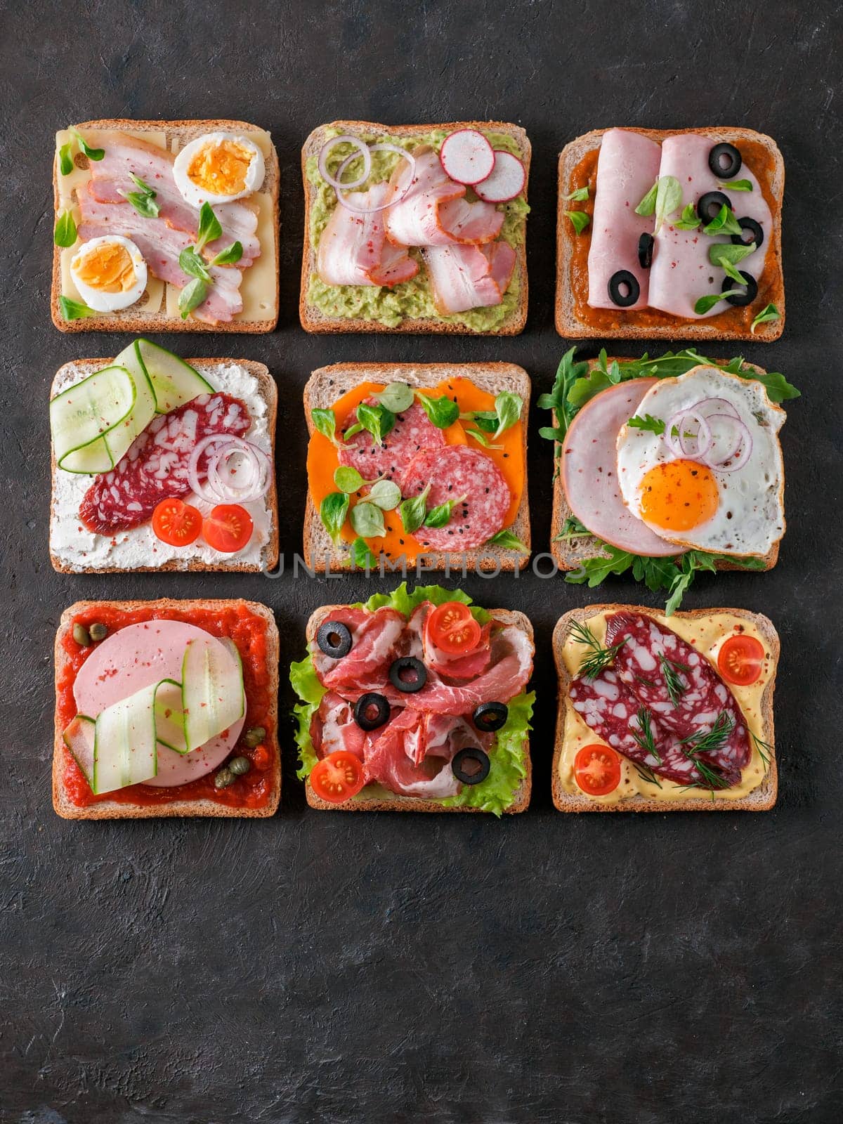 Set of eight different sandwiches with meat in square shape, copy space for text. Top view or flat lay. Assortment meat toasts on black background. Idea, creative concept for sausage maker. Vertical