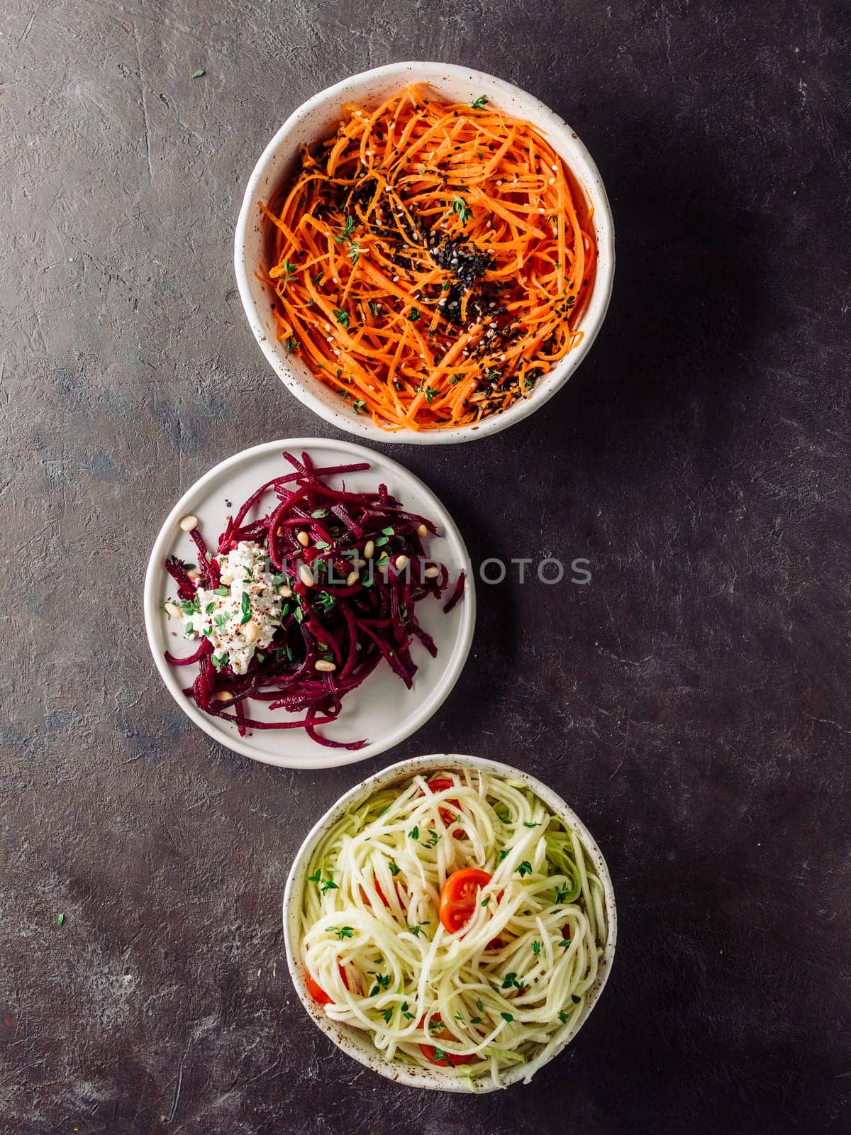 Ideas and recipes for healthy salad - spicy sesame carrot noodles salad,raw beetroot noodles wih ricotta,zucchini zoodles salad with tomatoes.Various vegetarian salads ready-to-eat.Top view.Copy space