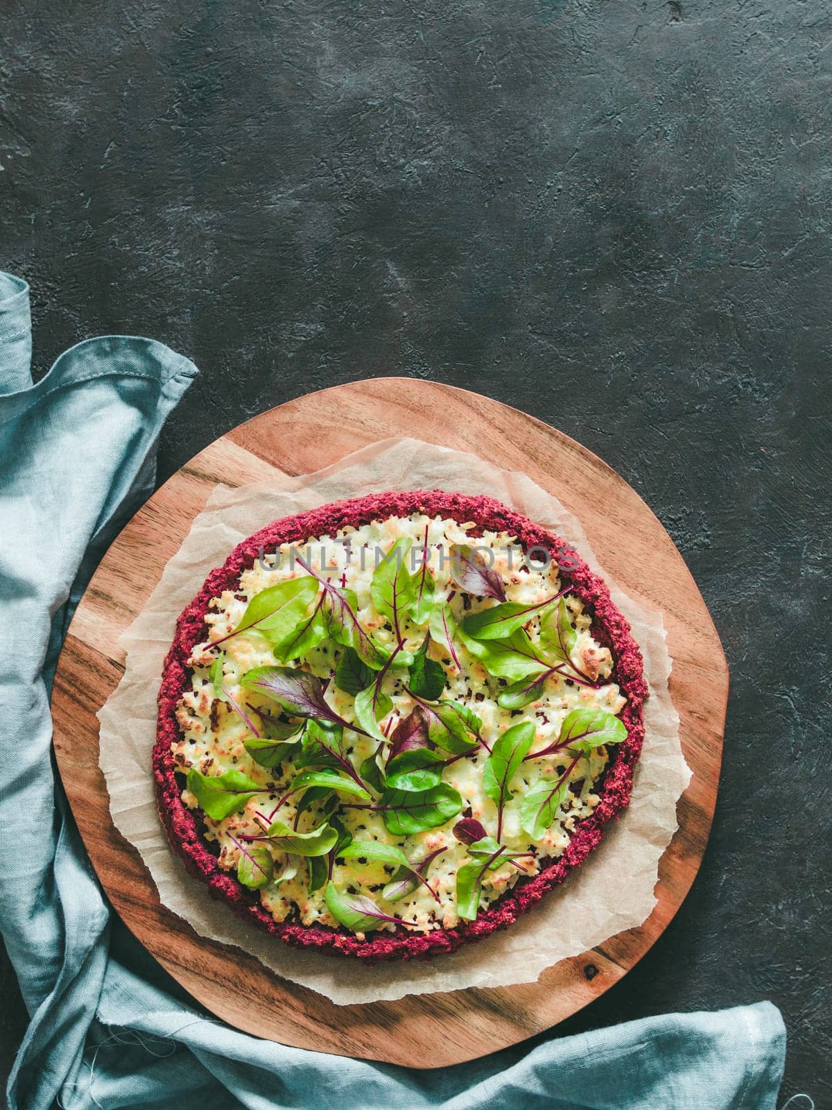 beetroot pizza crust with fresh swiss chard or mangold beetroot leaves.Ideas and recipes for healthy vegan snack.Egg-free pizza crust with chia seed and wholegrain brown rice flour.Copy space.Top view