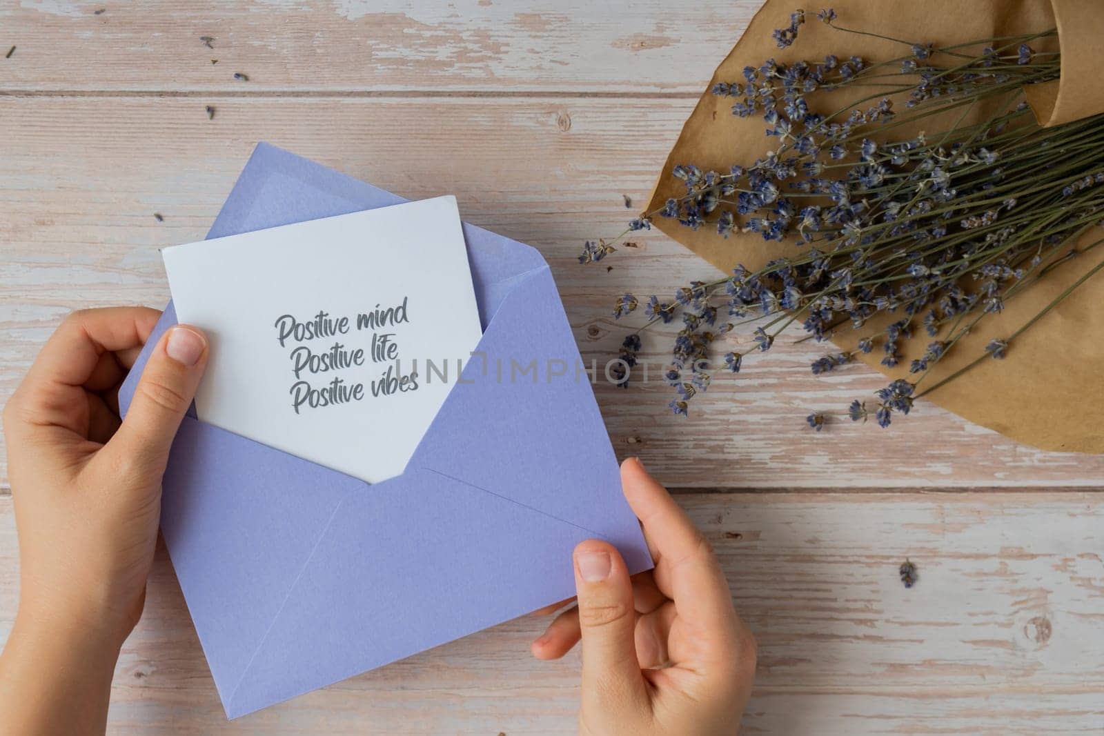 POSITIVE MIND LIFE VIBES text on supportive message paper note reminder from violet envelope. Flat lay composition dry lavender flowers. Concept of inner happiness, slowing-down digital detox personal fulfillment. Top view