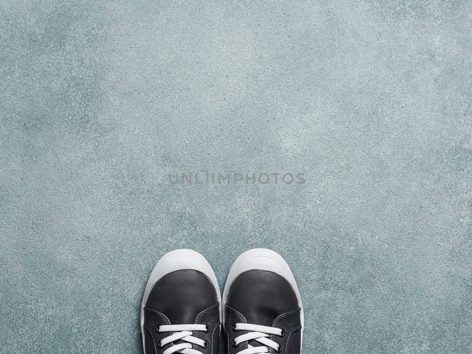 Gray and yellow sneakers on gray background by fascinadora