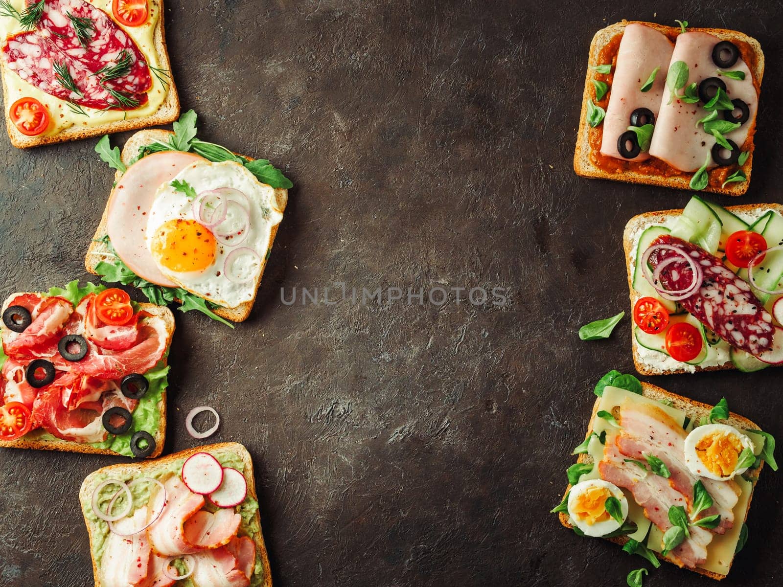 Set of eight different sandwiches with meat, copy space for design or text in center. Top view or flat lay. Assortment meat toasts on black background. Idea, creative concept for sausage maker