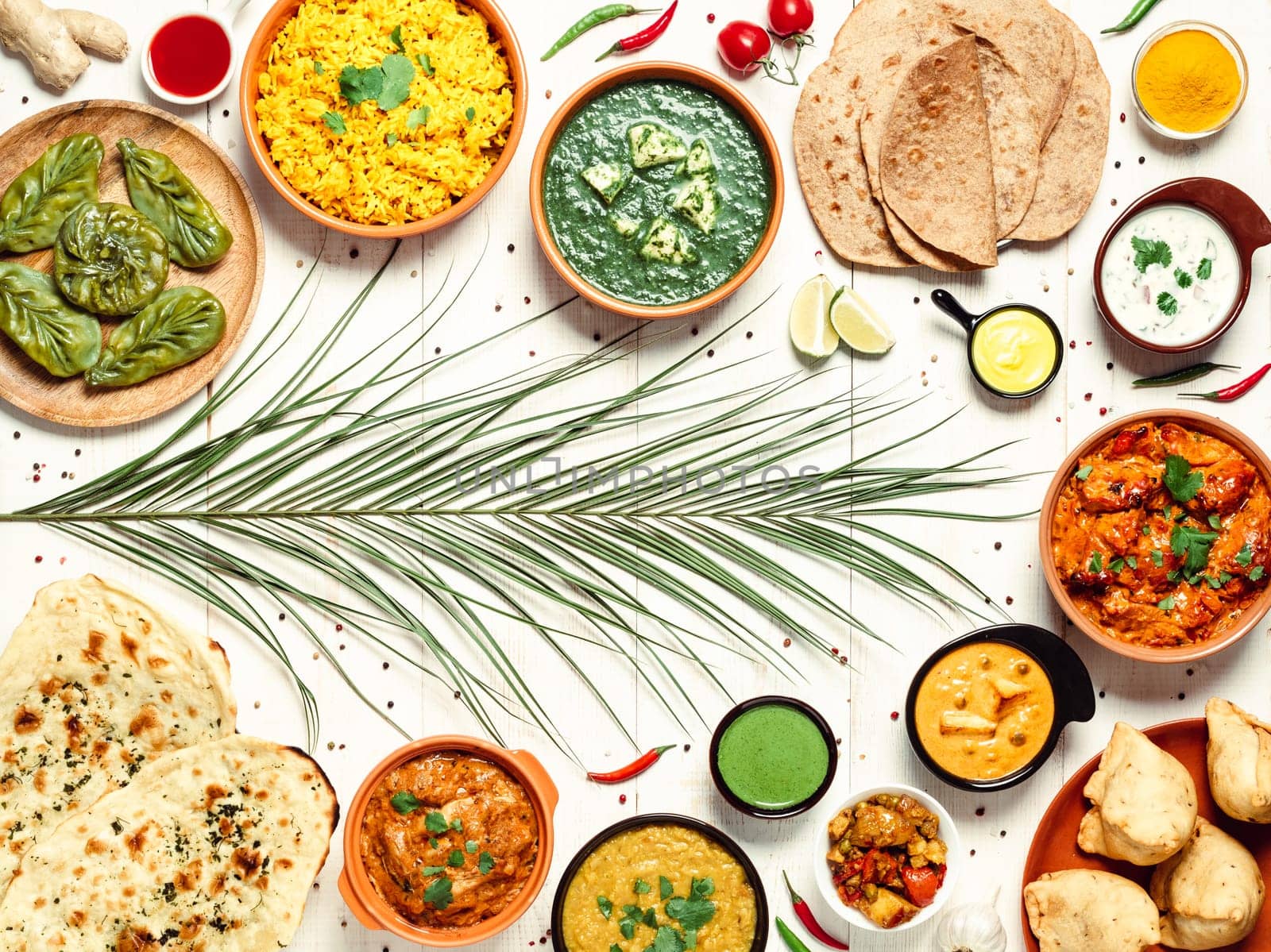 Indian cuisine dishes: tikka masala, dal, paneer, samosa, chapati, chutney, spices. Indian food on white wooden background. Assortment indian meal with copy space for text. Top view or flat lay.