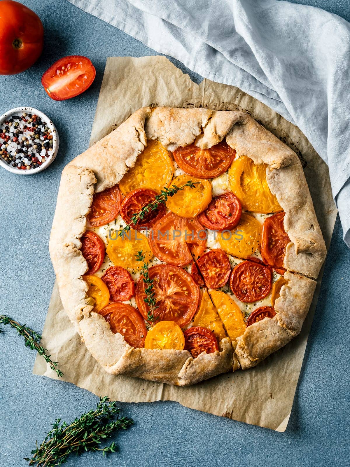 Savory fresh homemade tomato tart or galette.Ideas and recipes for healthy lunch,appetiezer- whole wheat or rye-wheat pie with tomatoes,parmesan cheese,mozzarella.Harvest tomatoes.Flat lay.Vertical