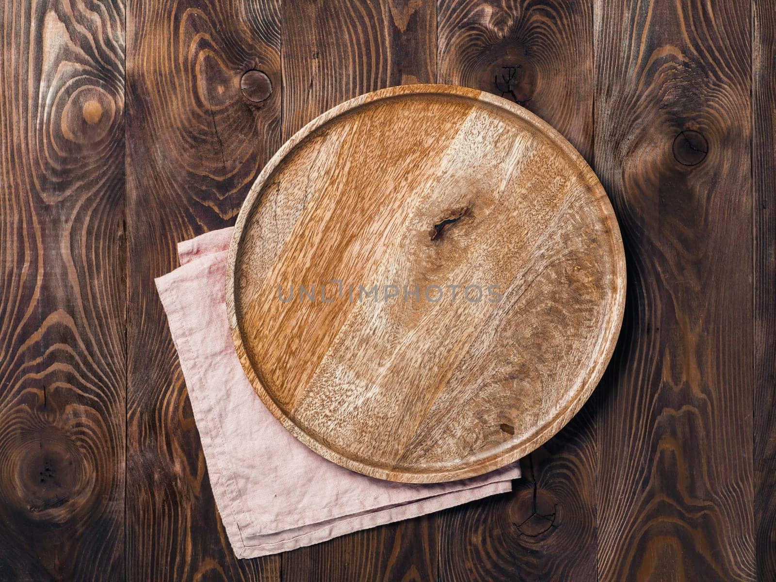Empty wooden plate and napkin on table by fascinadora