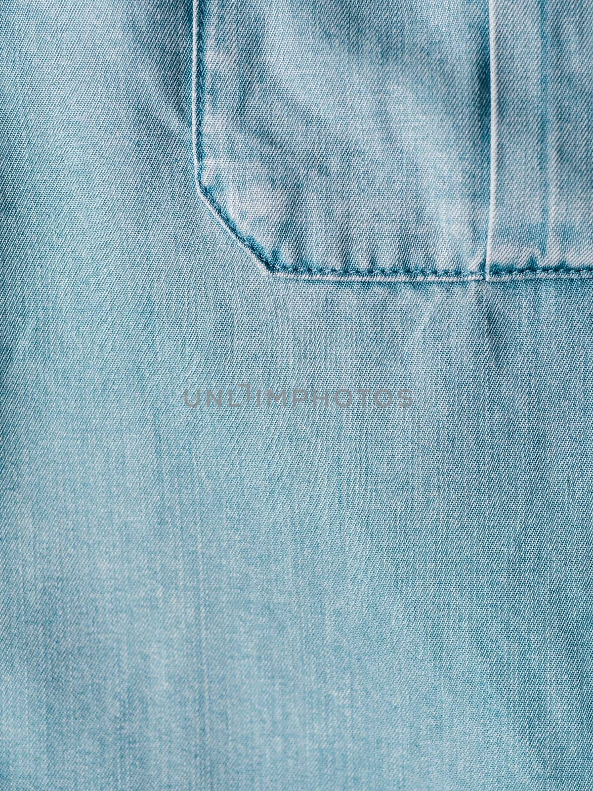 Modern soft jeans blouse with breast pocket texture close up. Lyocell or tencel pattern - modern natural cellulose fabric blue denim color. Can use for design or text. Copy space