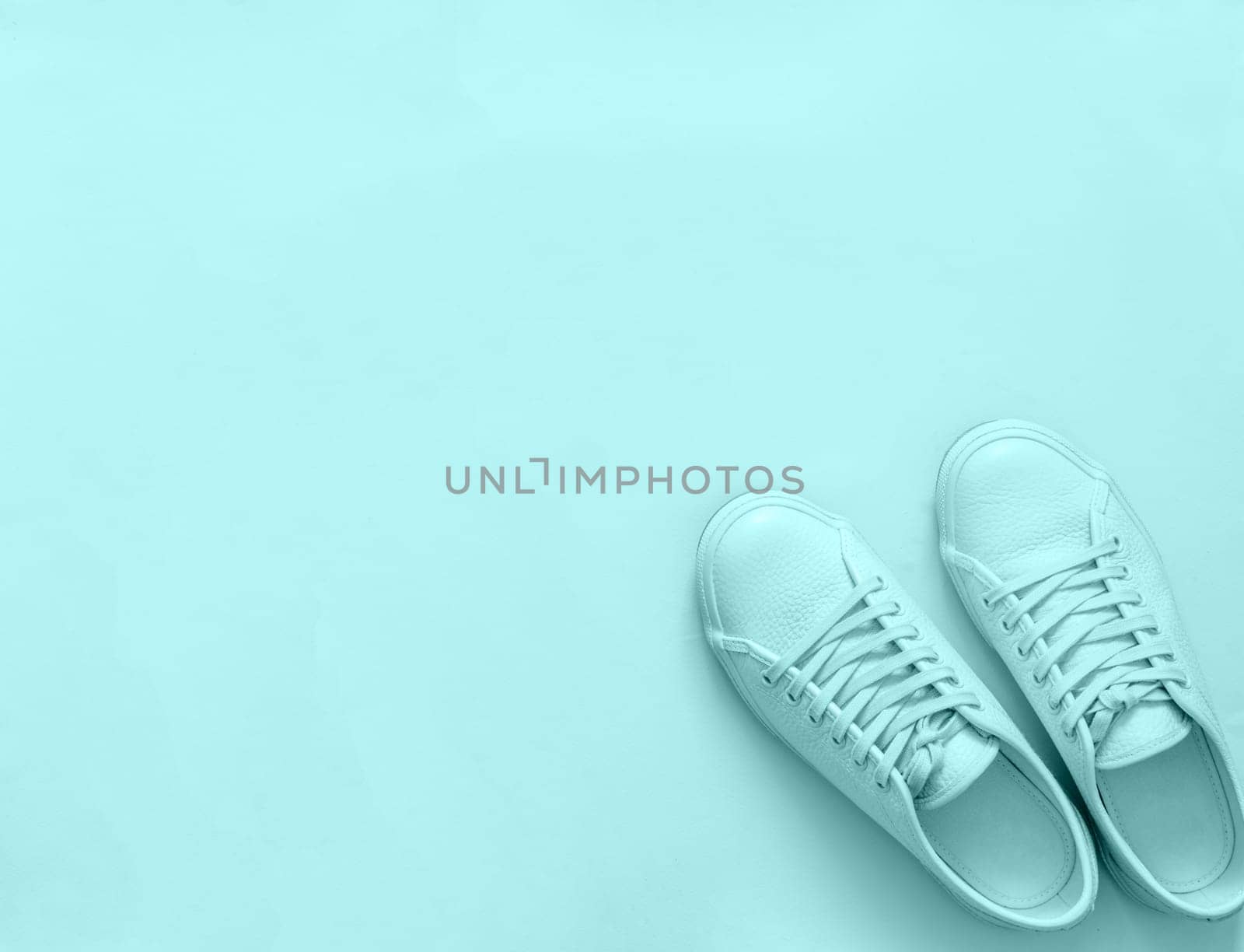 Blue sneakers on blue background, copy space by fascinadora