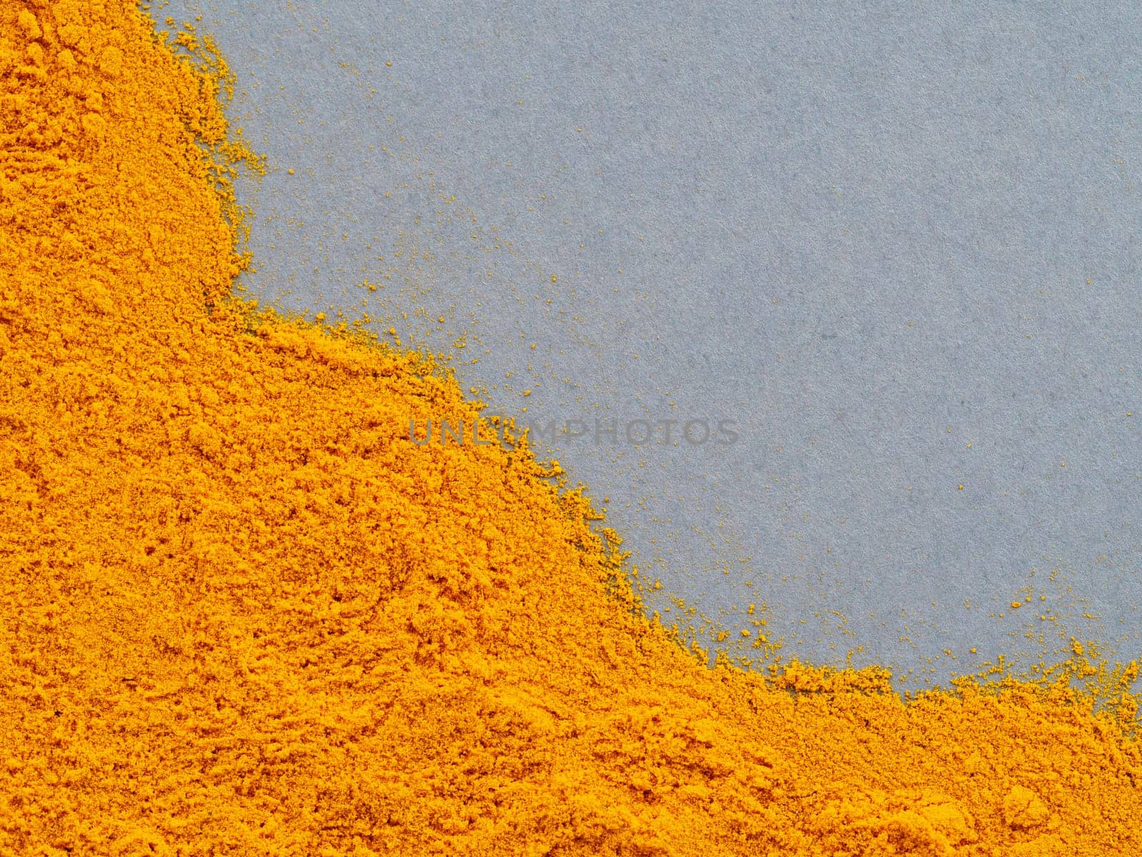 Turmeric Powder or Curcuma longa on gray background. Top view. Copy space for text.