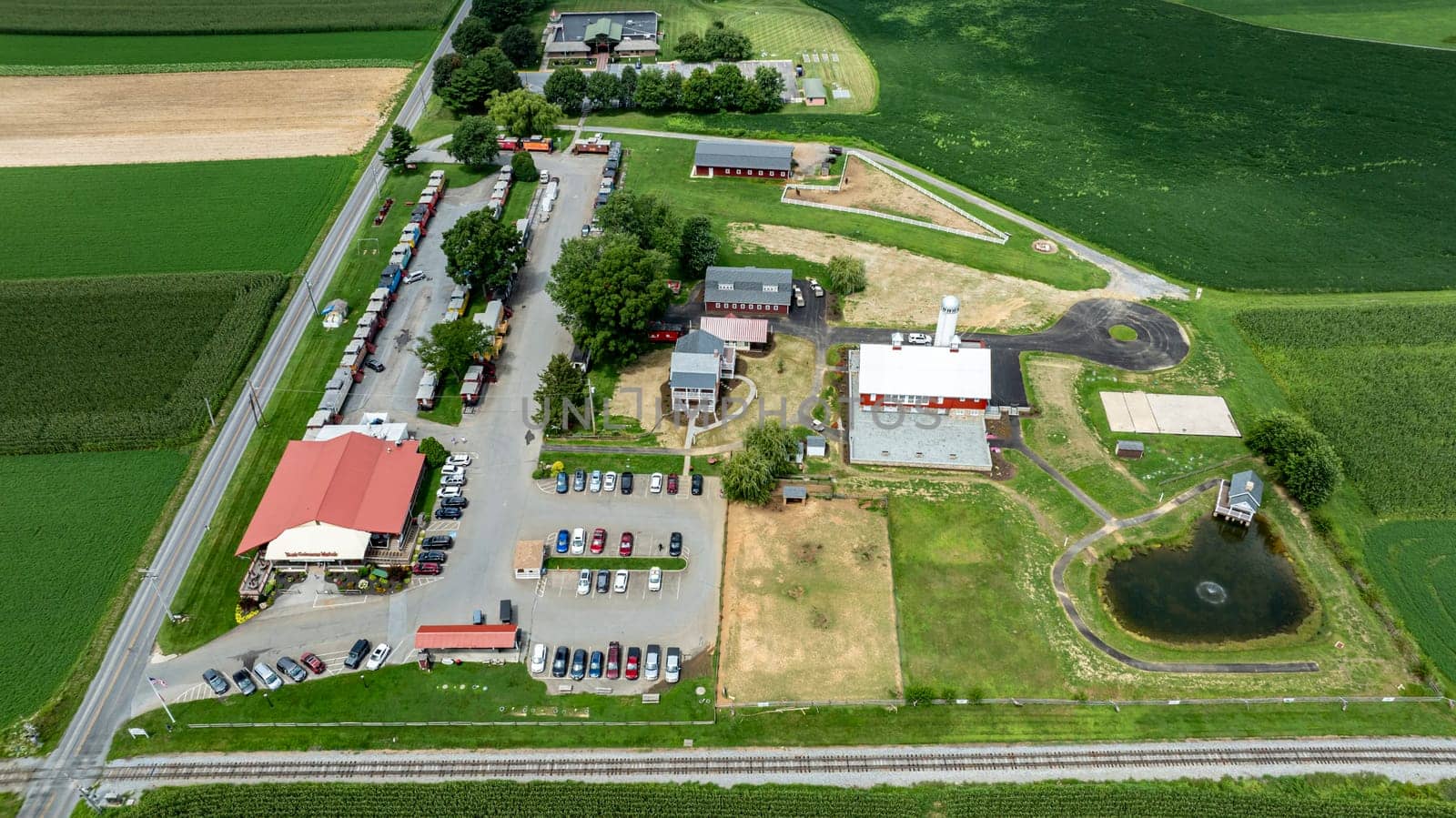 Ronks, Pennsylvania, August 15, 2023 - his aerial image features a central rural business hub with parking and buildings, bordered by the lush green patterns of surrounding farmlands.