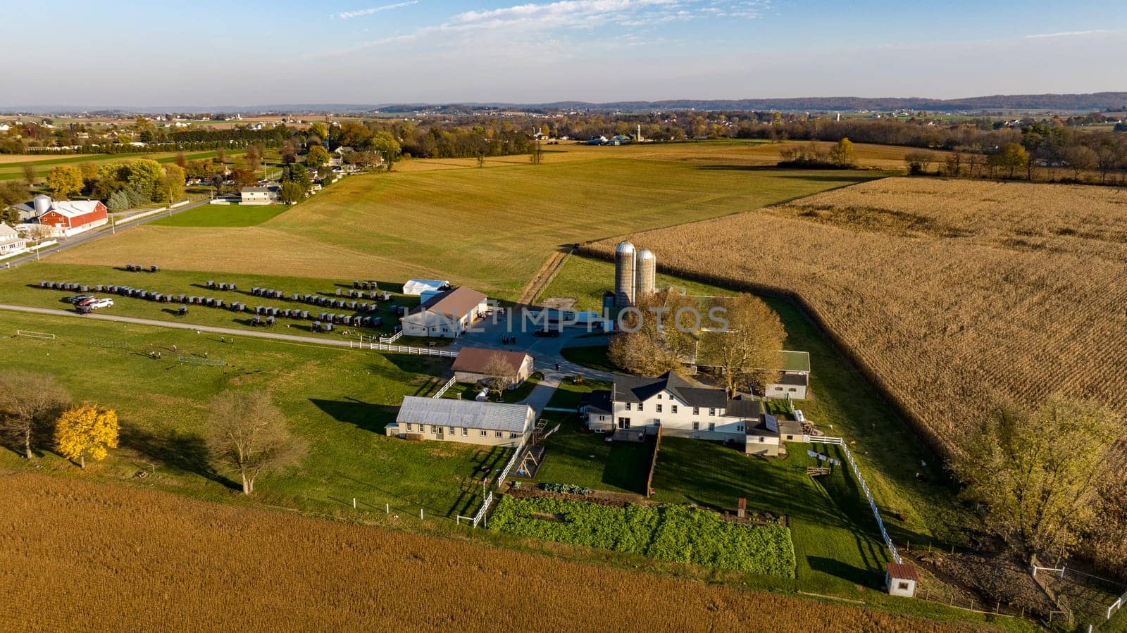 Ronks, Pennsylvania, November 7, 2023 - As the sun sets, this aerial view highlights a farm after the harvest, with its distinctive silos and buildings, embodying the essence of rural life and the agricultural cycle. having an Amish wedding