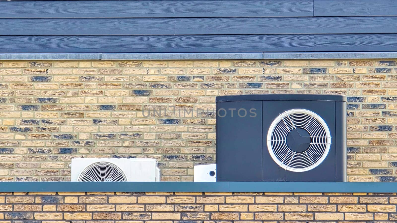 air source heat pump unit installed outdoors at a modern home with bricks in the Netherlands at spring, warmte pomp translation air source heat pump , airco and heat pump