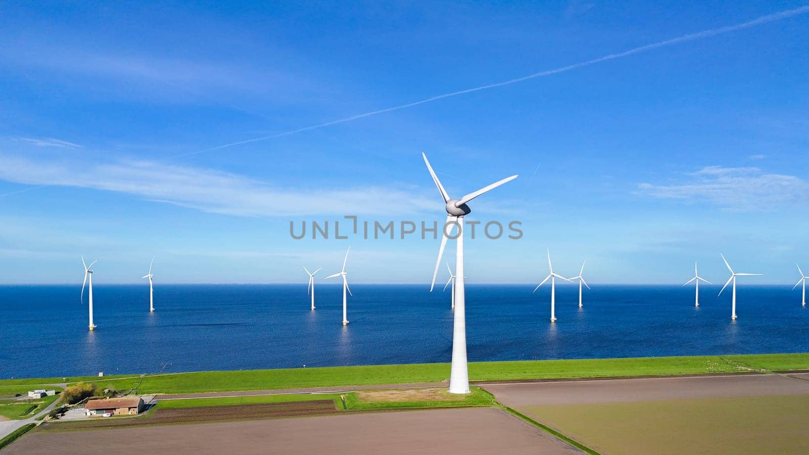 offshore windmill park and a blue sky, windmill park in the ocean. Netherlands Europe. windmill turbines in the Noordoostpolder Flevoland, clean green energy, carbon neutral, Earth day