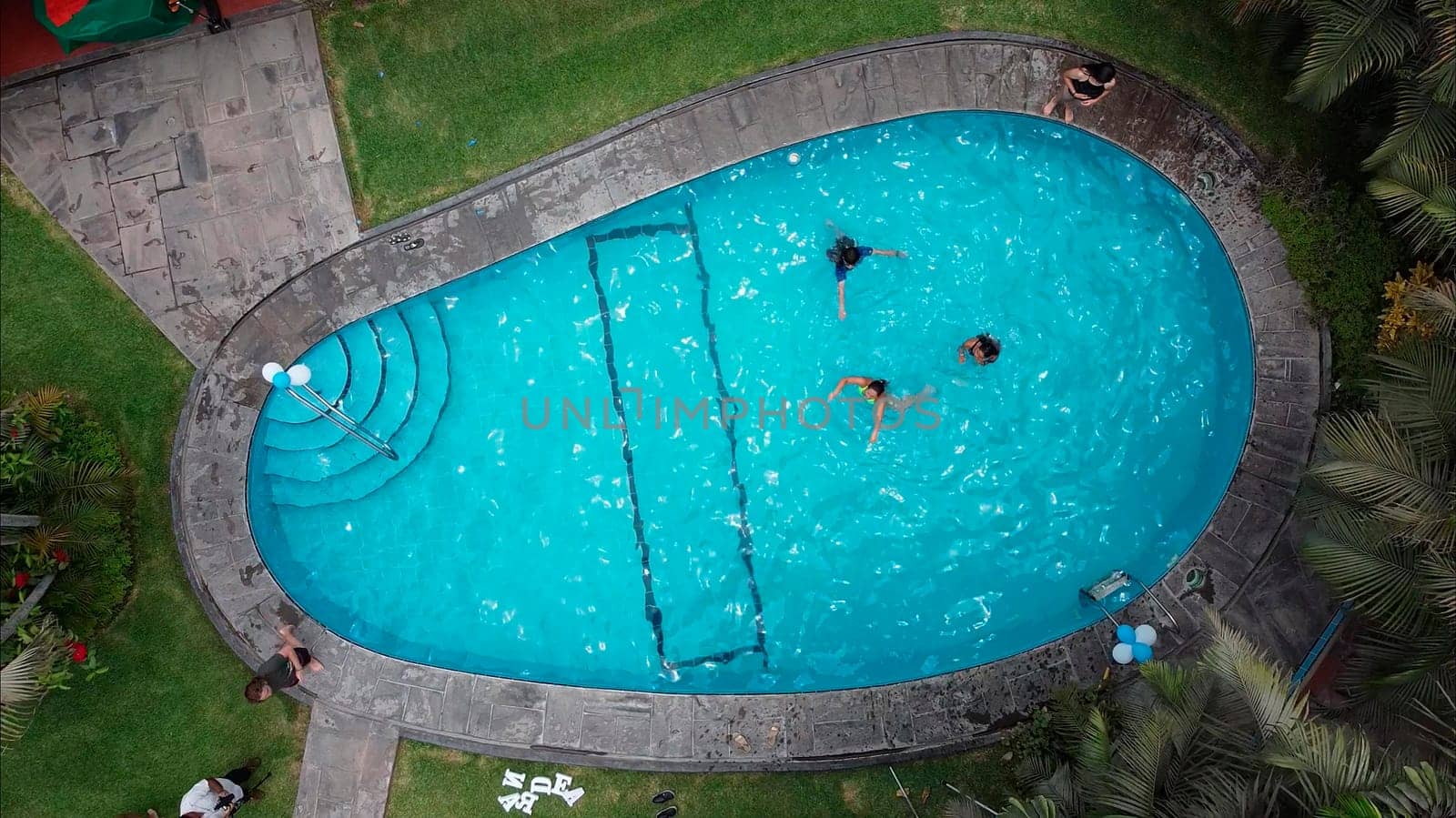 Aerial video shot of a pool where unrecognizable group of friends fun. 2.7k video resolution. by Peruphotoart