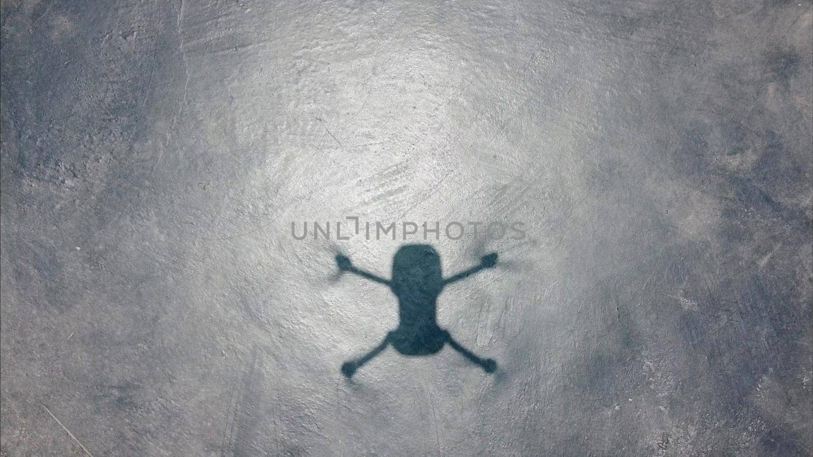 Shadow of a small drone on the pavement. by Peruphotoart