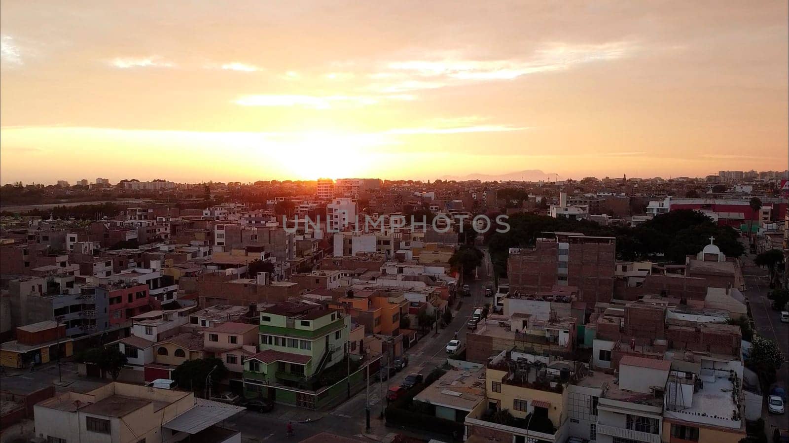 Aerial view of a cityscape bathed in the warm hues of a tranquil sunset