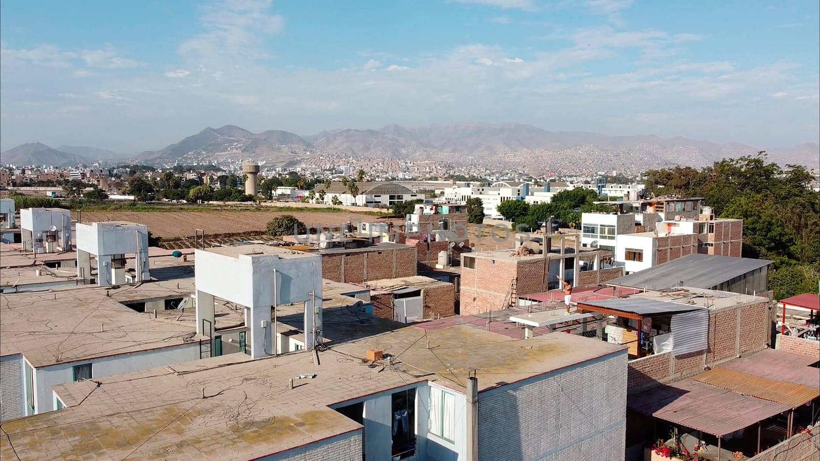Aerial view of a sprawling urban area with residential buildings and distant mountains