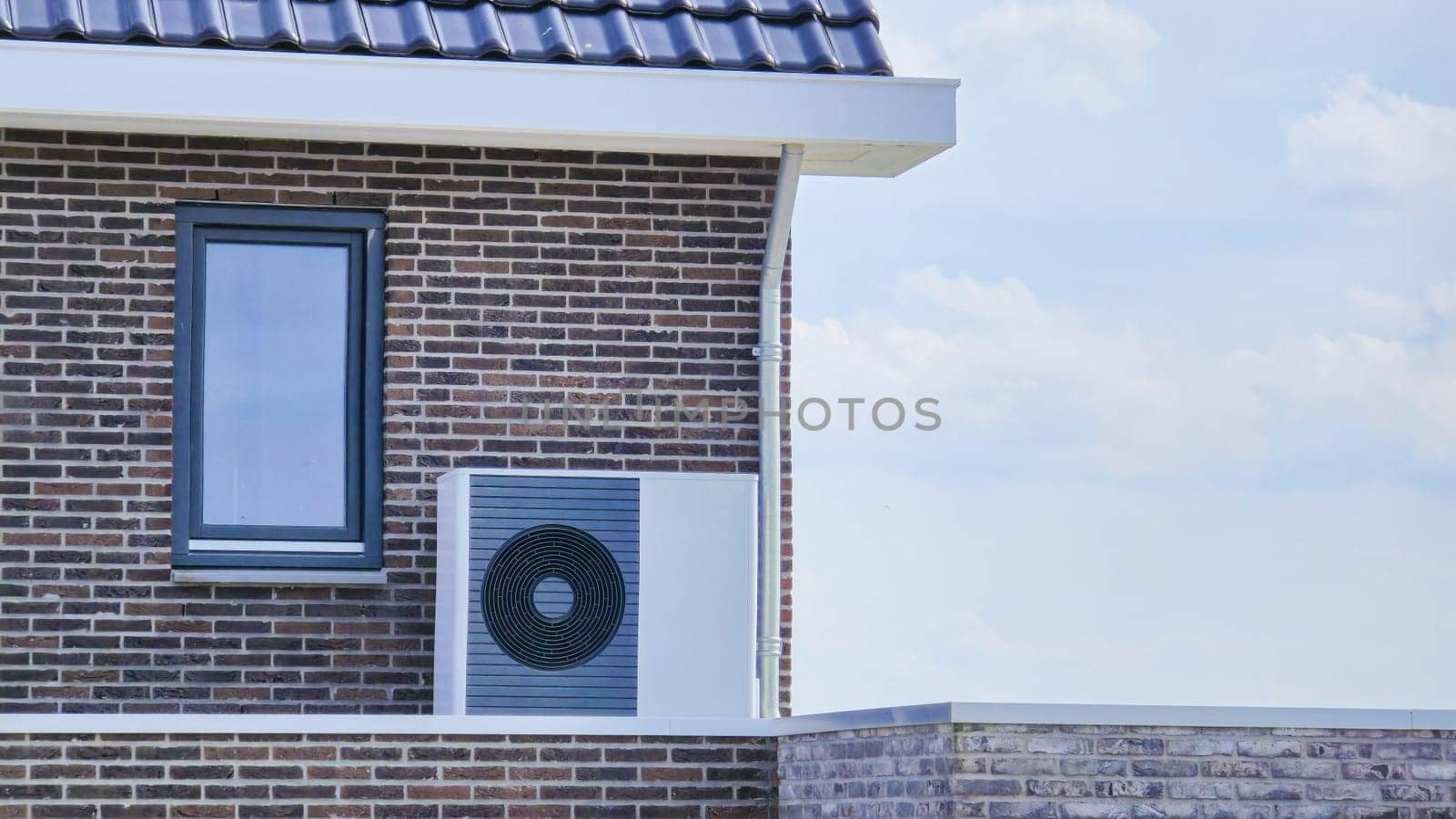 air source heat pump unit installed outdoors at a modern home with bricks in the Netherlands at spring, warmte pomp translation air source heat pump , eco friendly zero waste