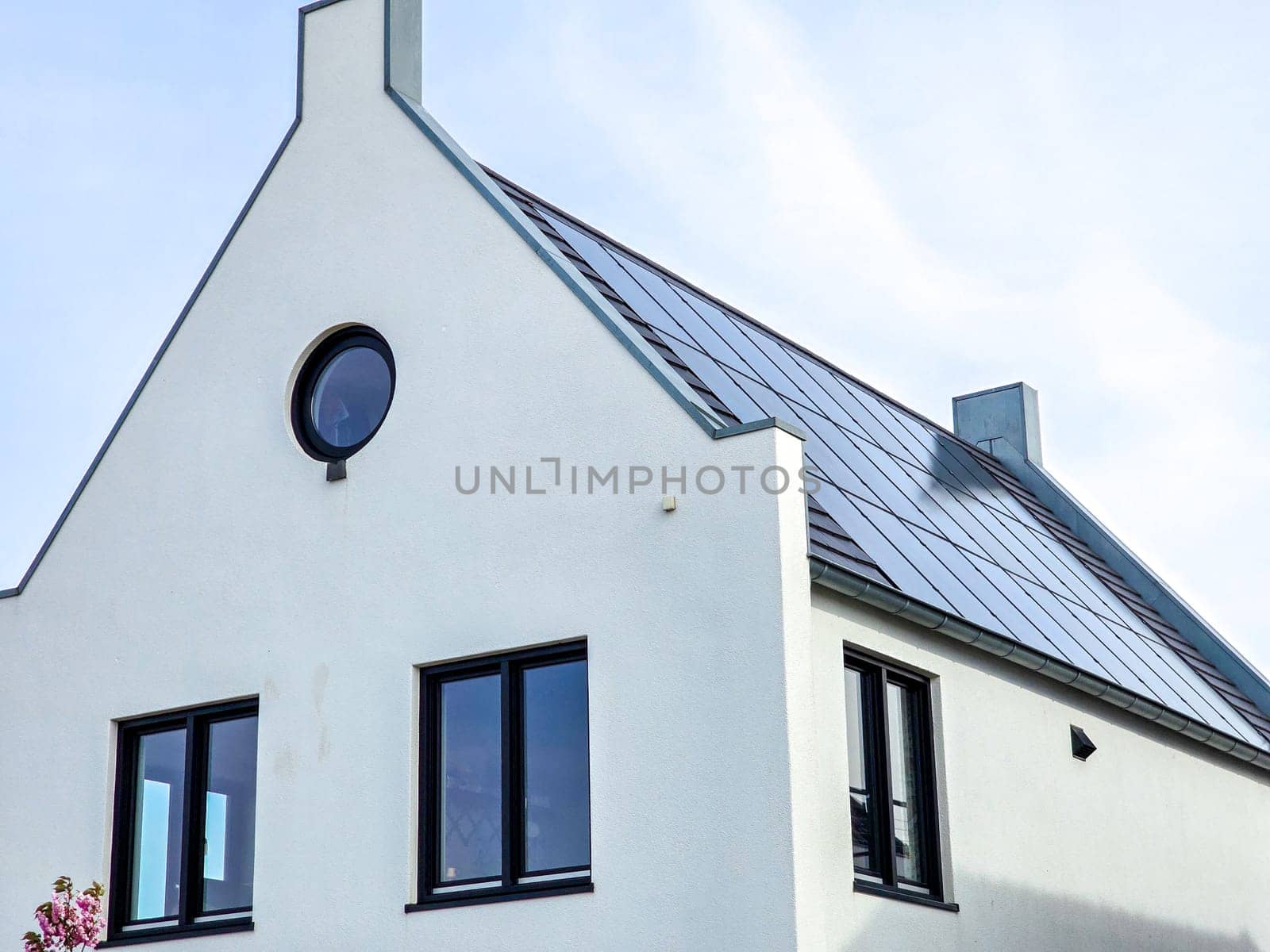 Newly build houses with solar panels attached on the roof against a sunny sky by fokkebok