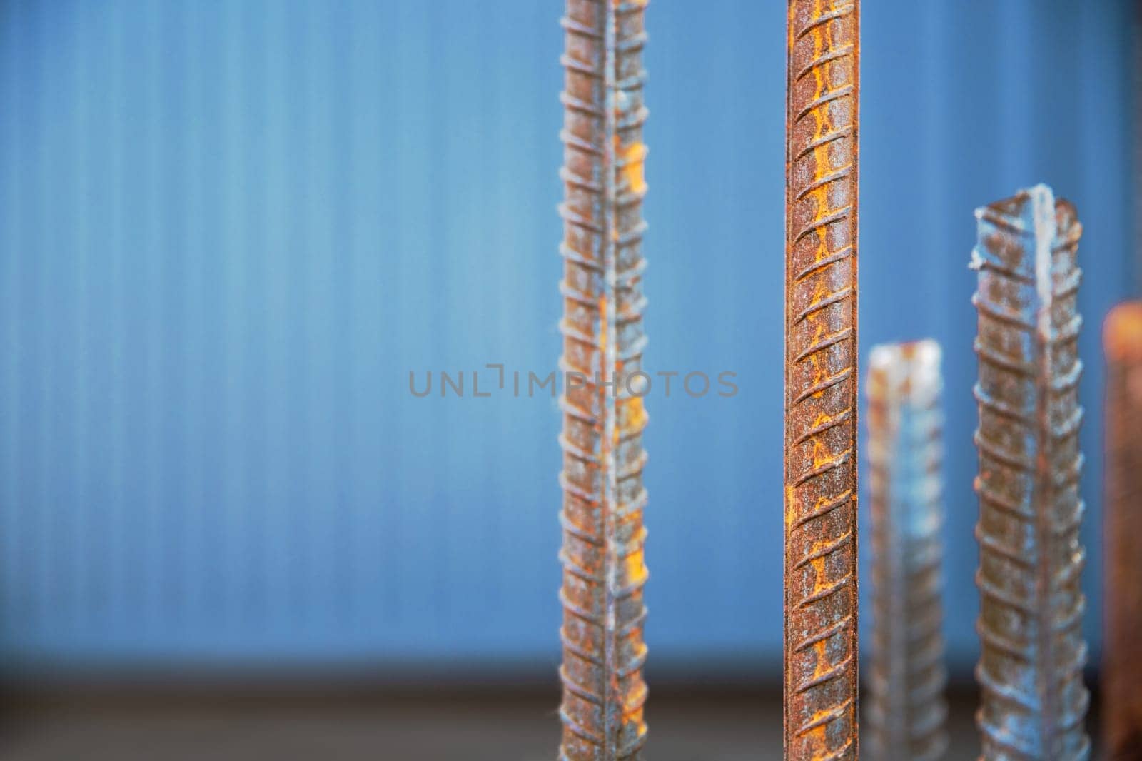 Steel bars, also known as steel reinforcement bars, are employed on construction sites to reinforce concrete, copy space, close-up and selective soft focus by Rom4ek