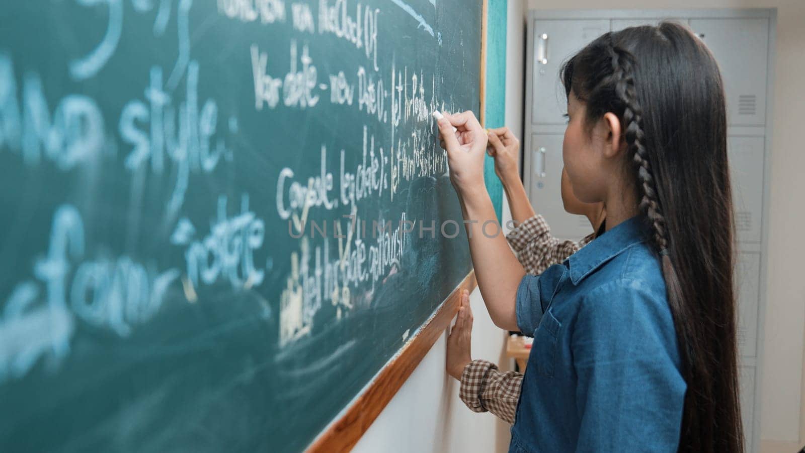 Skilled asian girl writing engineering prompt and programing system while standing blackboard with generated AI prompt written by diverse smart student at STEM technology lesson. Education. Pedagogy.