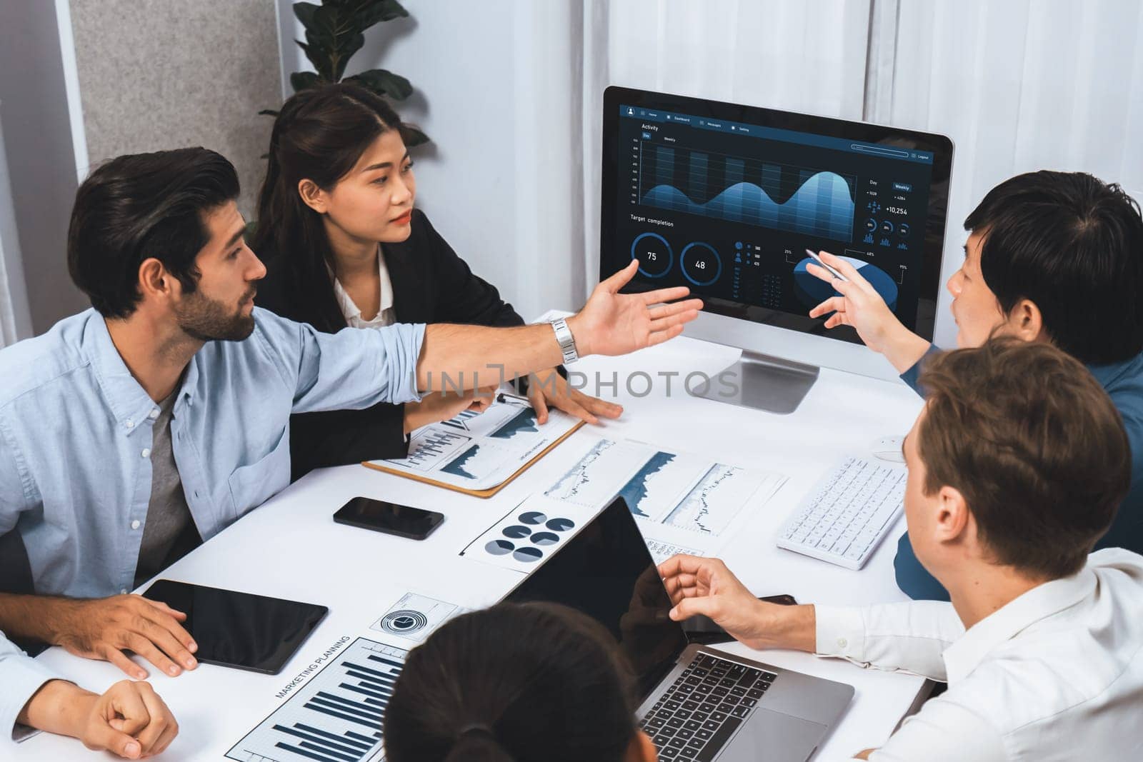 Analyst team utilizing BI Fintech to analyze financial data at table in meeting room. Businesspeople analyzing BI dashboard power for business insight and strategic marketing planning. Prudent