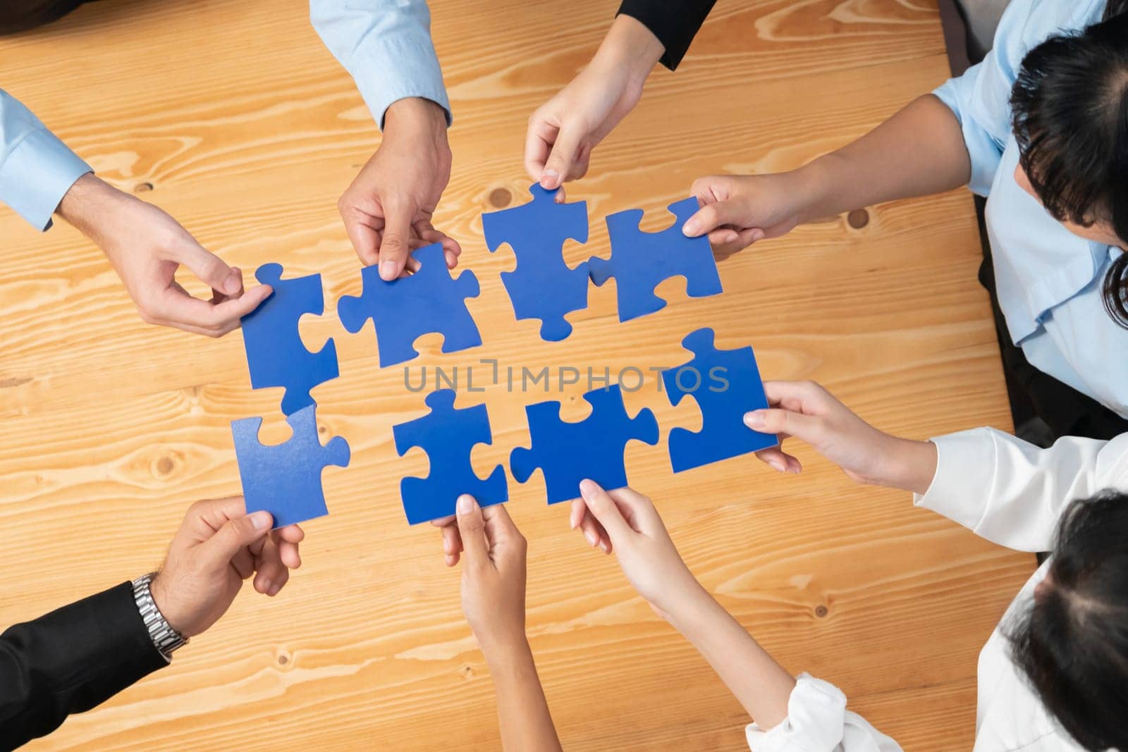 Multiethnic business people holding jigsaw pieces together. Habiliment by biancoblue