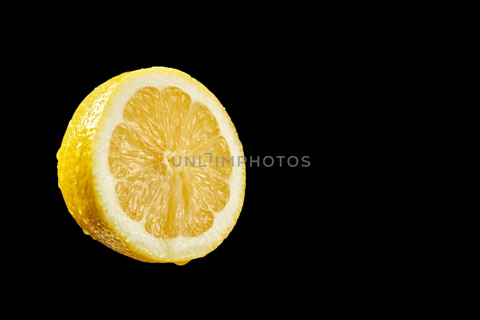 Closeup of half lemon with water droplets on black background by superstellar