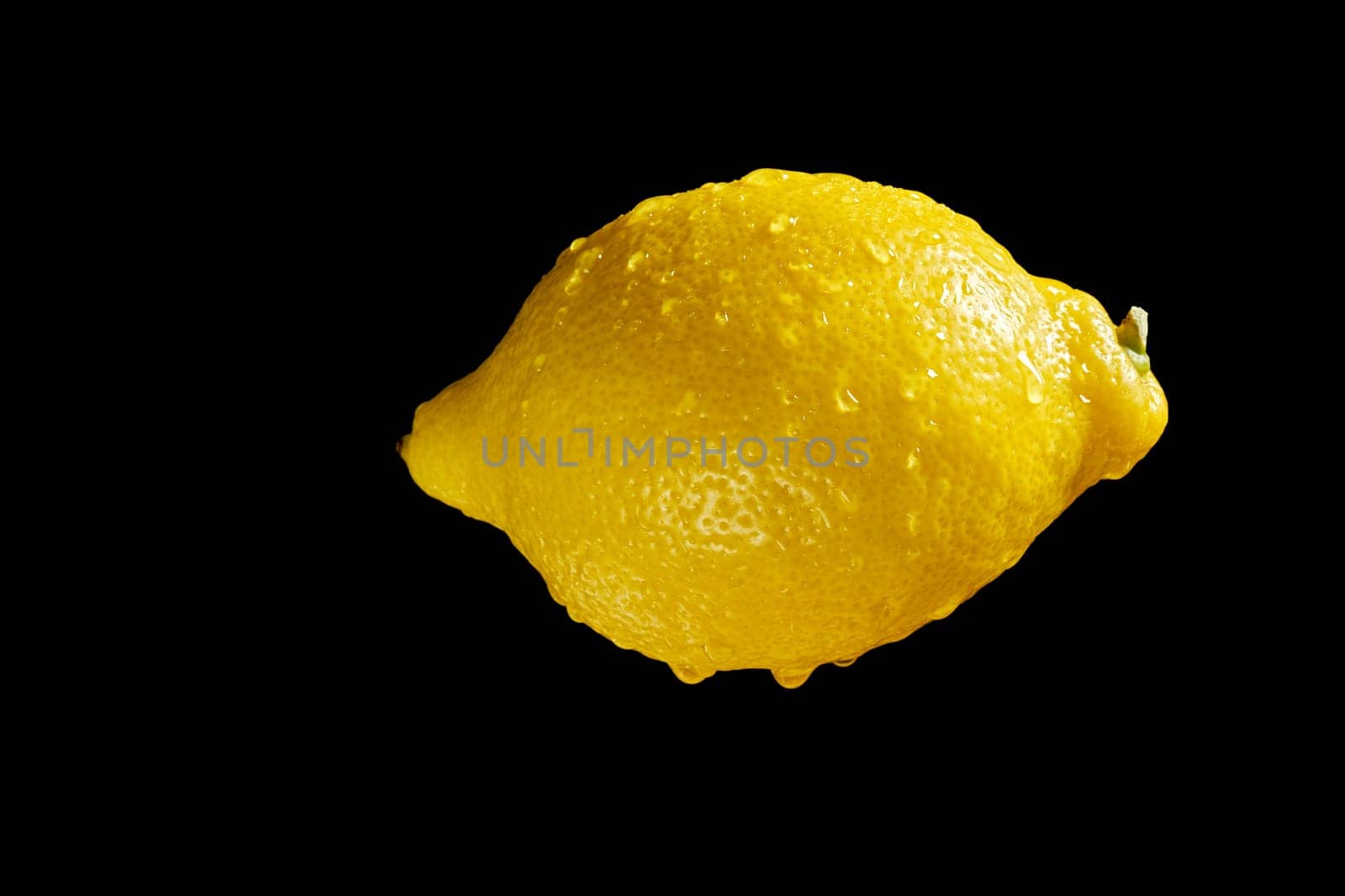 Close up of lemon with water droplets on black background by superstellar