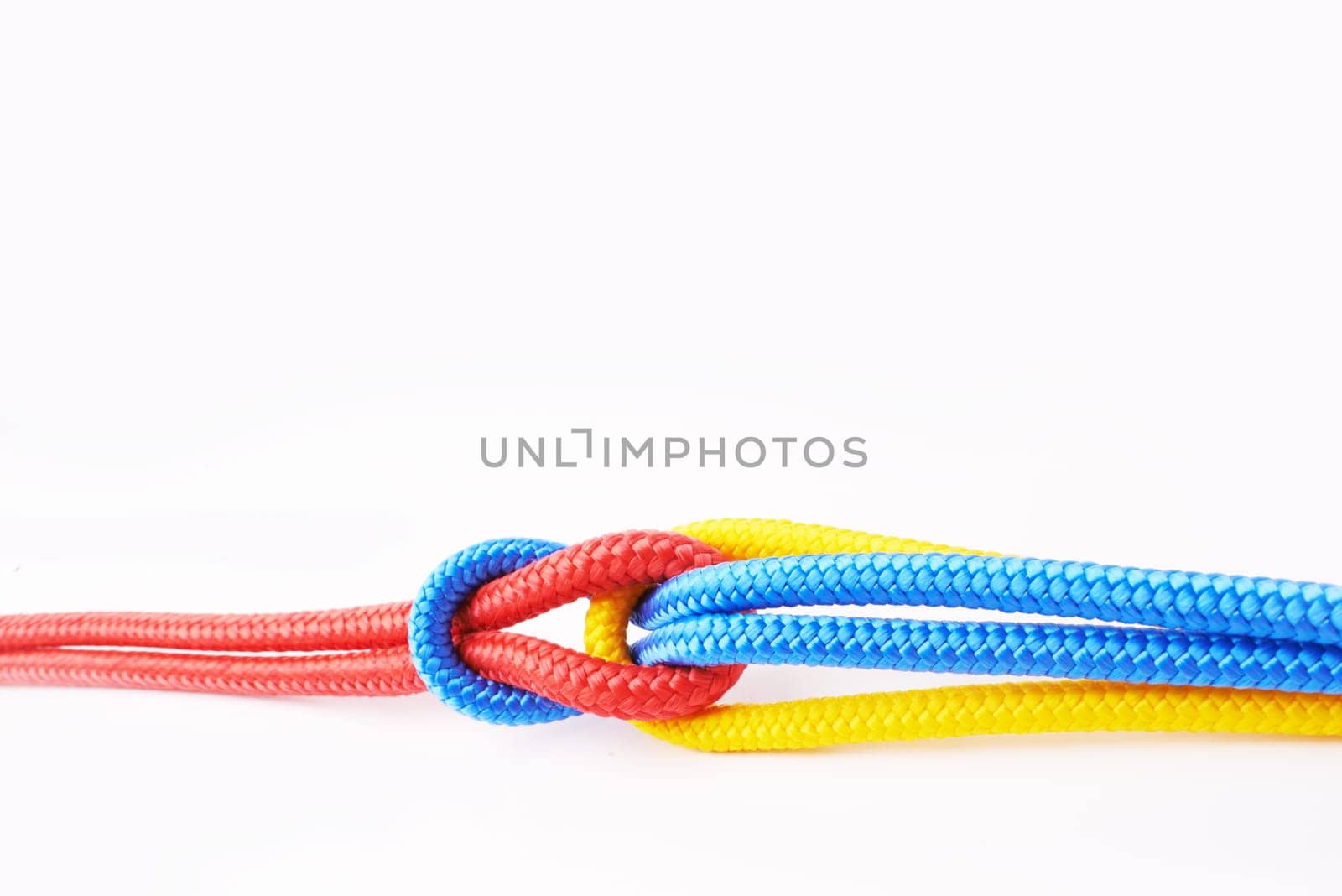 Colourful, ropes and tied for together in studio to represent unity, connect and trust. Secure, string and reef knotted for security to stop movement of objects safety on isolated white background by YuriArcurs