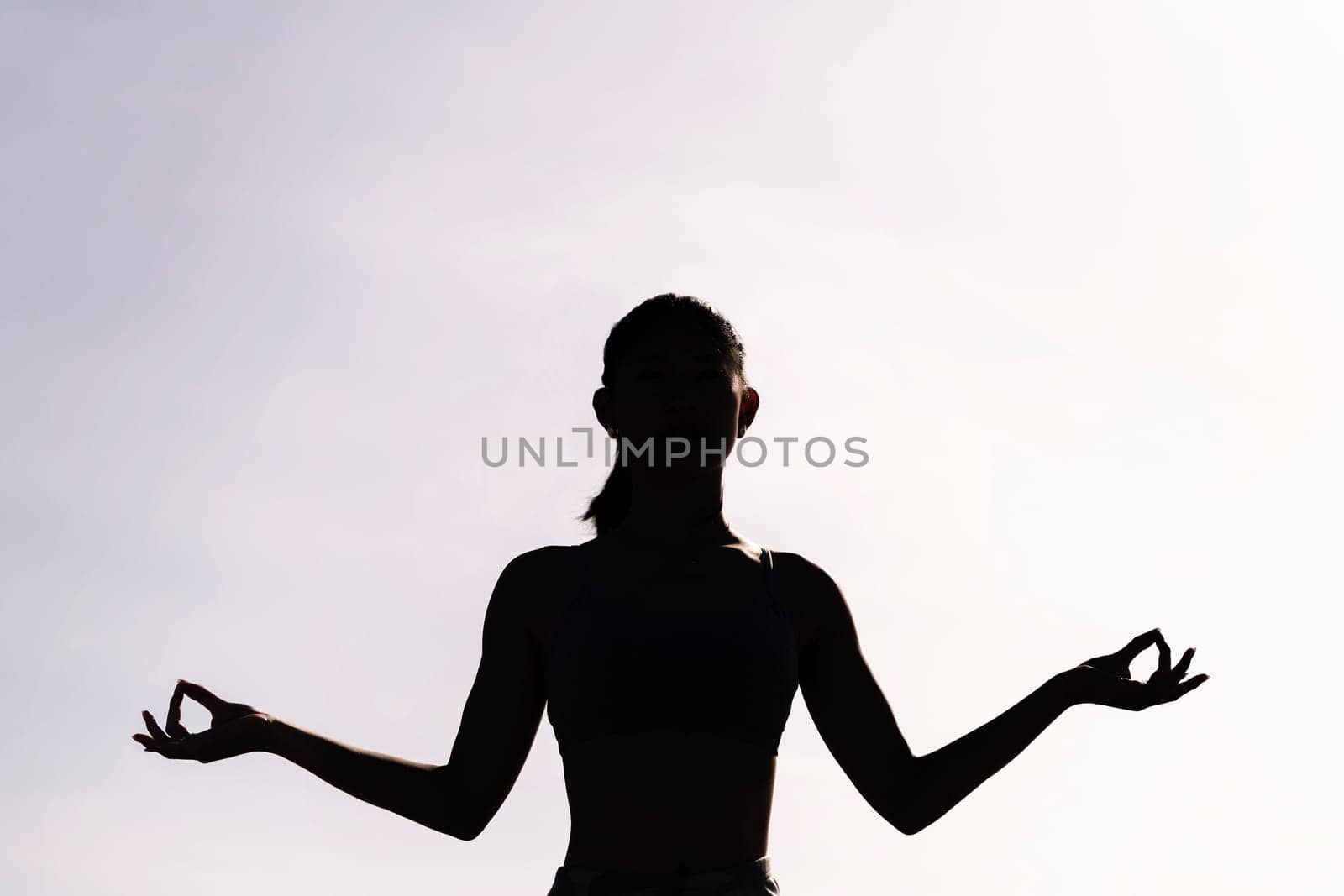 backlight of young woman doing yoga meditation by raulmelldo