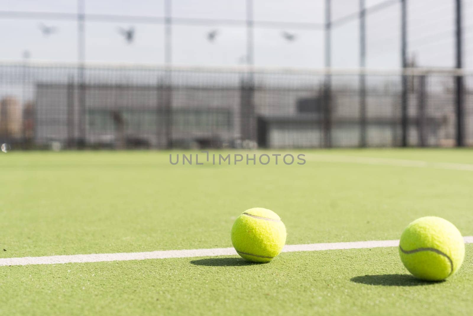 Bright greenish, yellow tennis ball on freshly painted court. High quality photo
