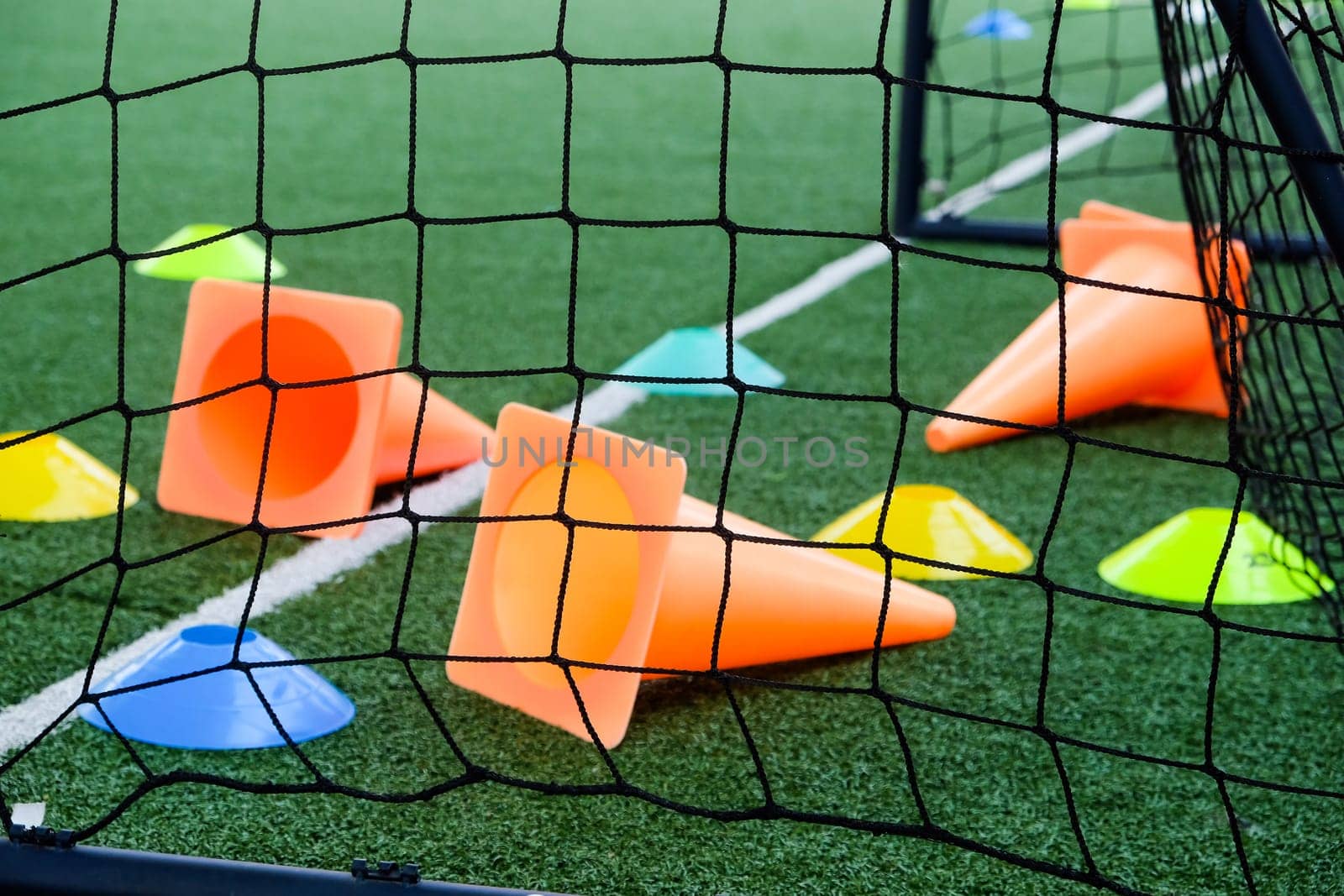 Soccer goal and cones on green artificial turf by ponsulak