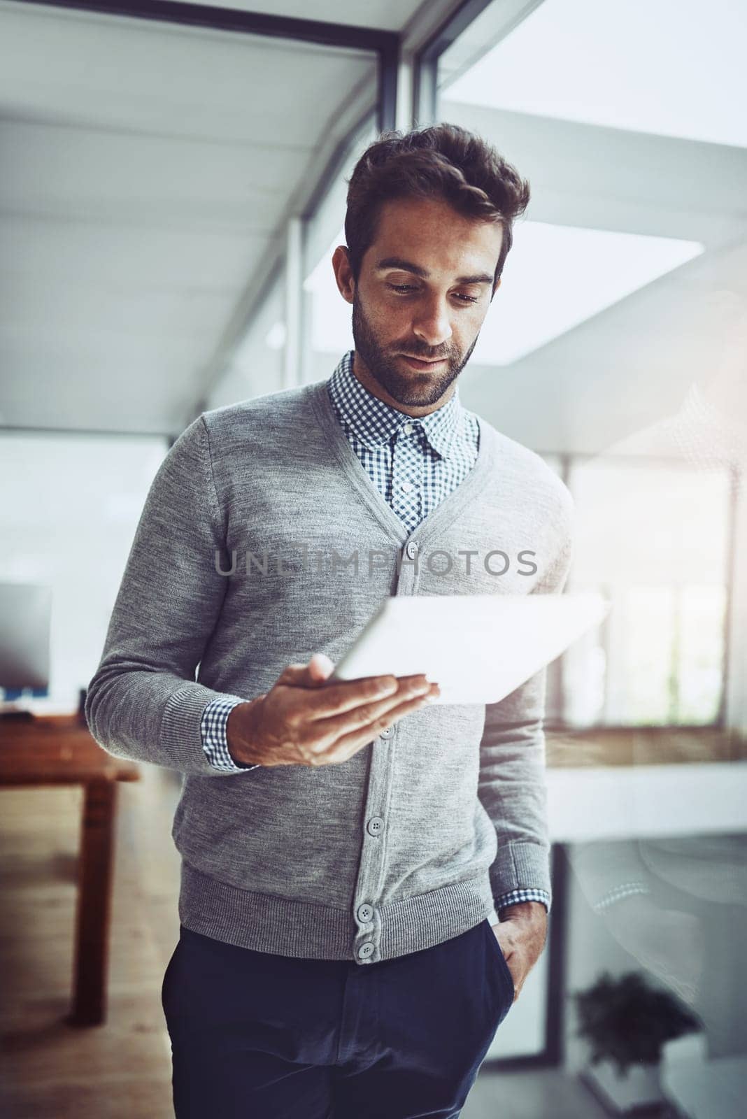 Serious, reading and businessman in office with tablet for contact, communication and work for corporate career. Vision, professional or broker with technology for internet in workspace or agency.