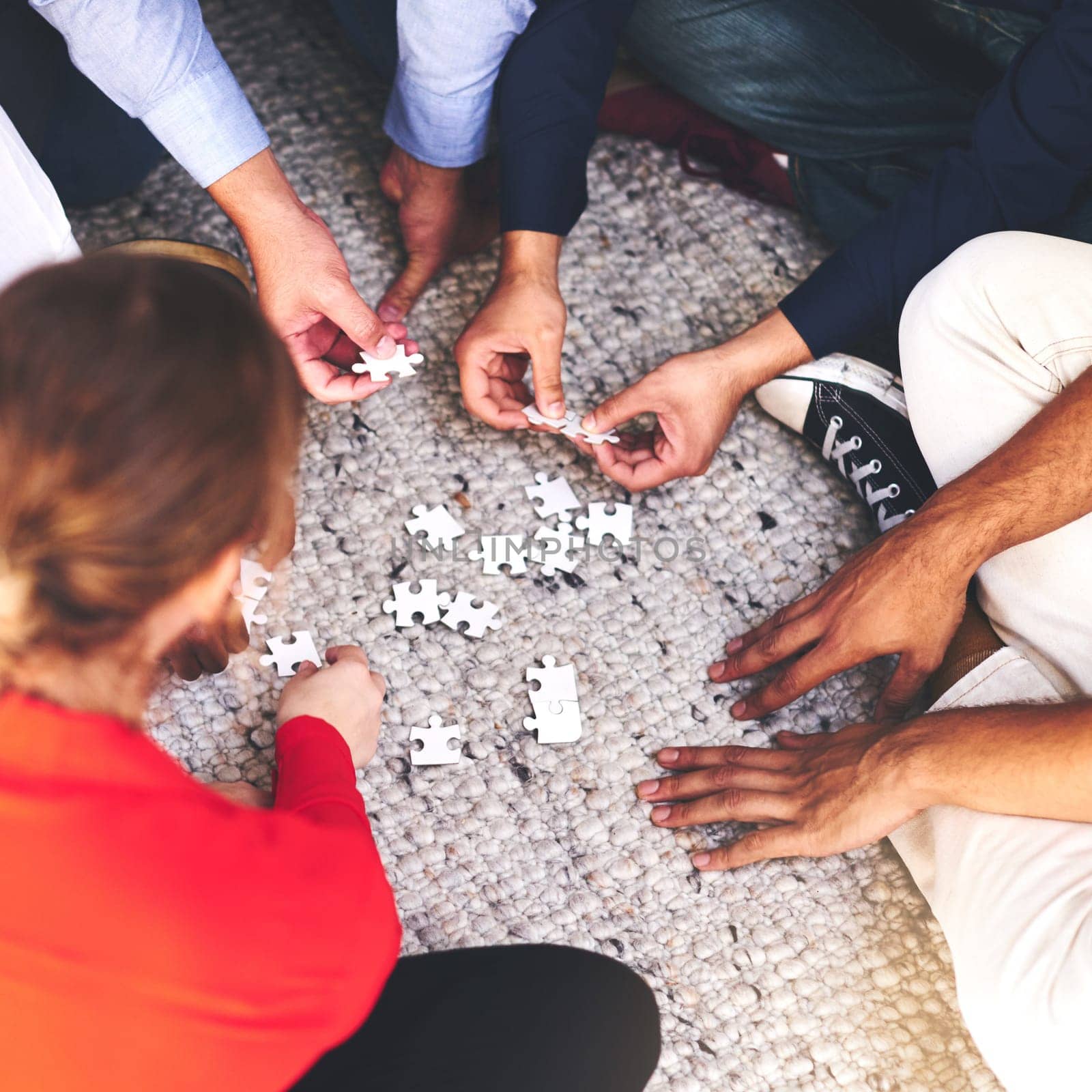Business, people and group with puzzle on floor for team building, common goal and problem solving in workplace. Top view, hands and collaboration for concentration skills, synergy and creativity by YuriArcurs